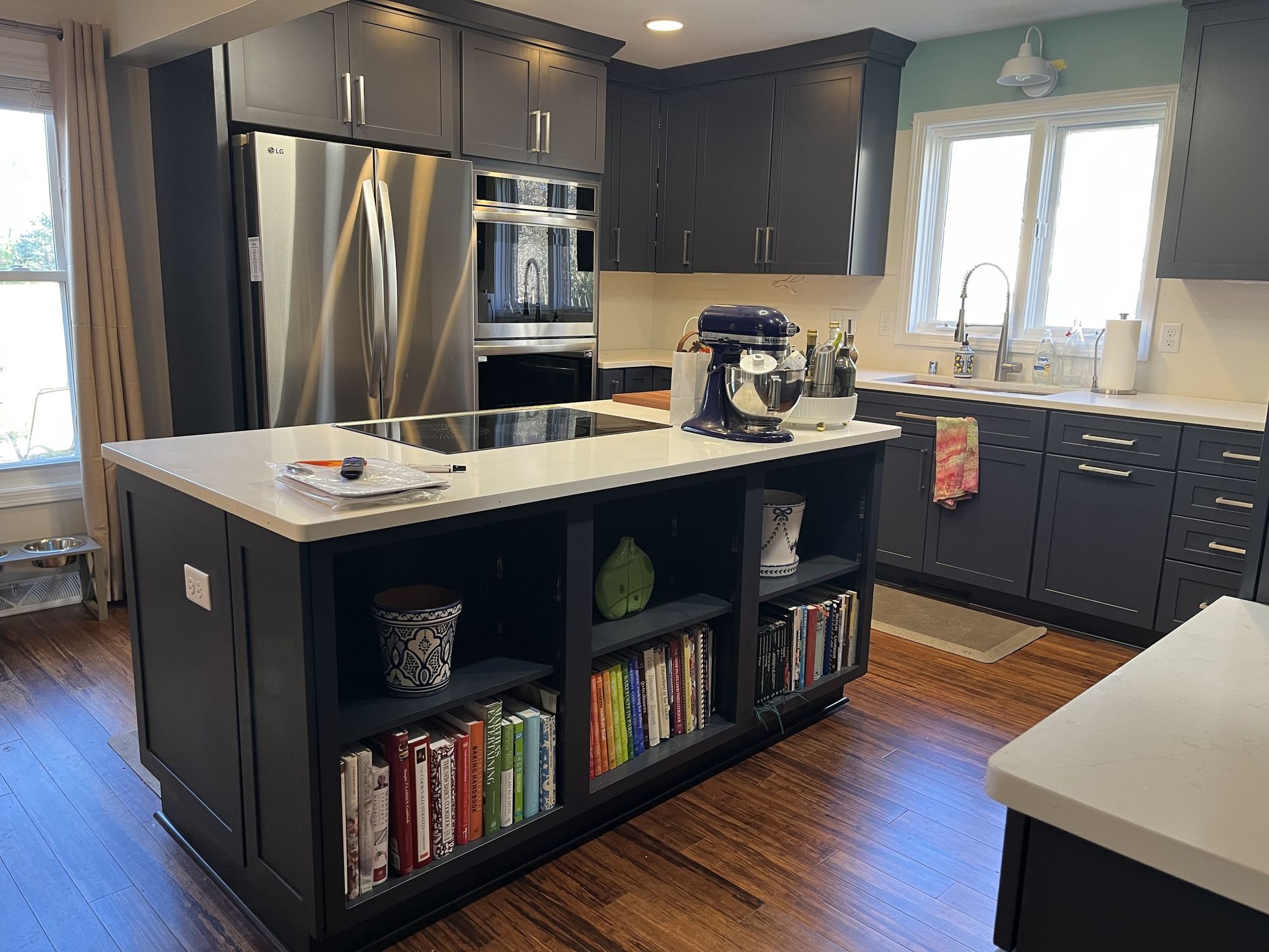 Dark gray kitchen with white countertops and a central island with cookbooks.