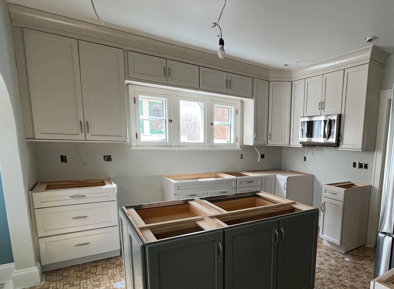 Kitchen with new cream cabinets, window, and island in progress.