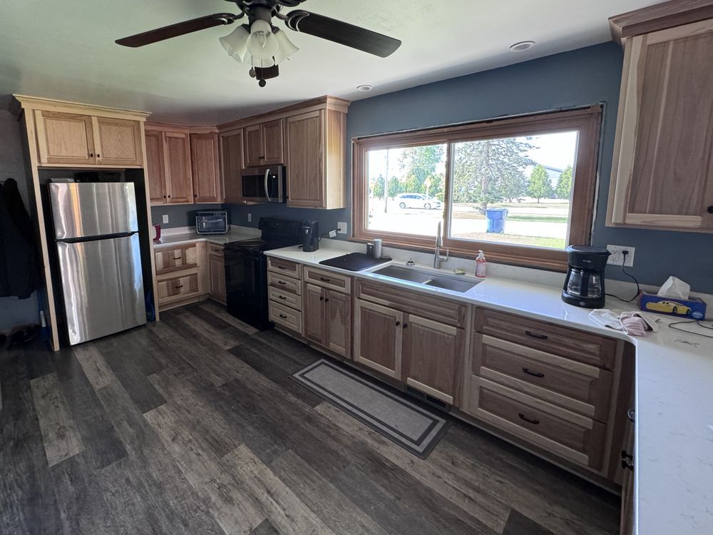 Kitchen with wood cabinets, stainless steel refrigerator, and dark gray flooring.