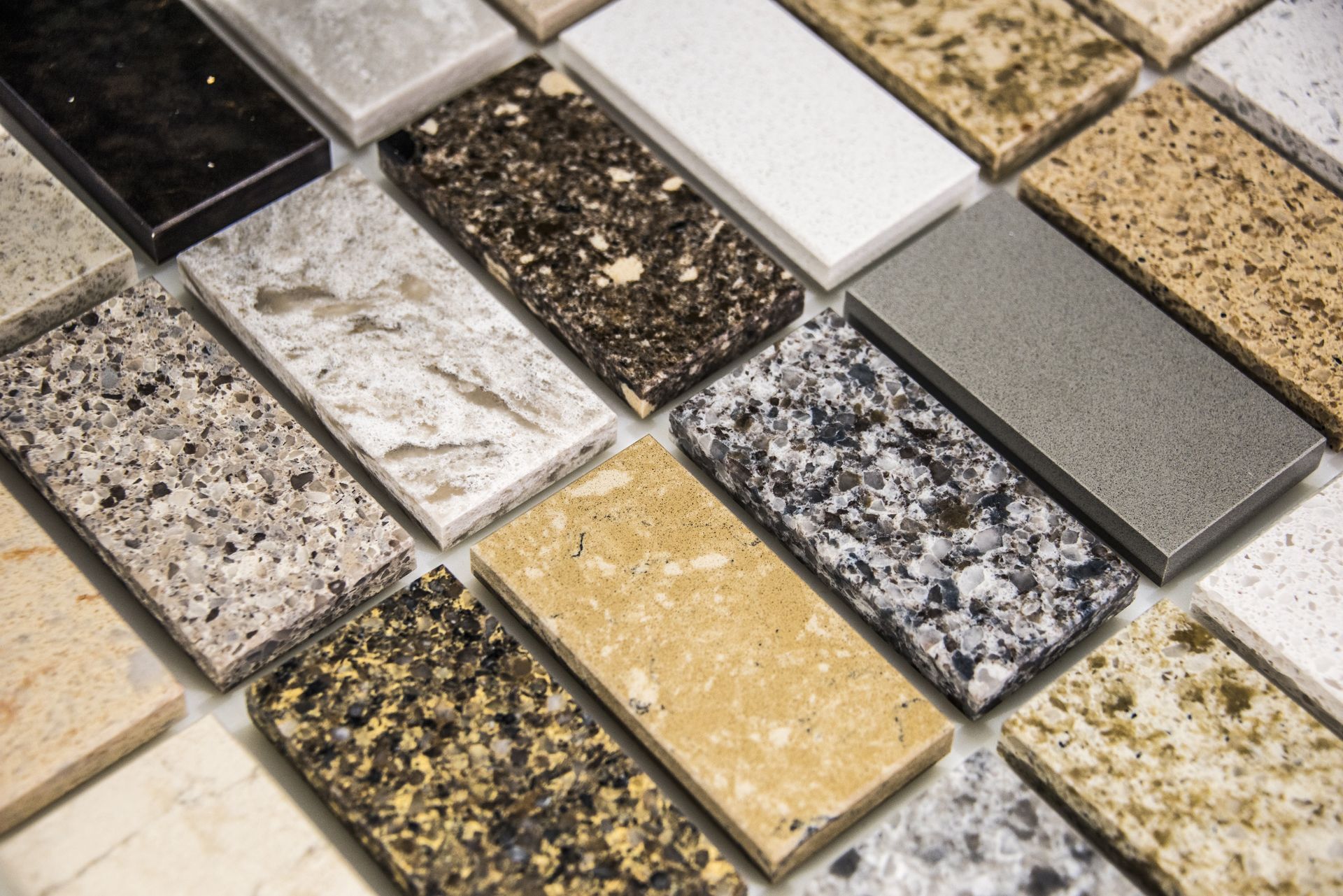 Various rectangular stone samples of countertops in different colors and patterns.