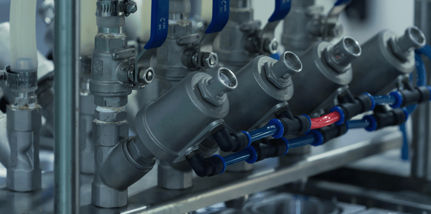 A close up of a row of valves and pipes in a factory.