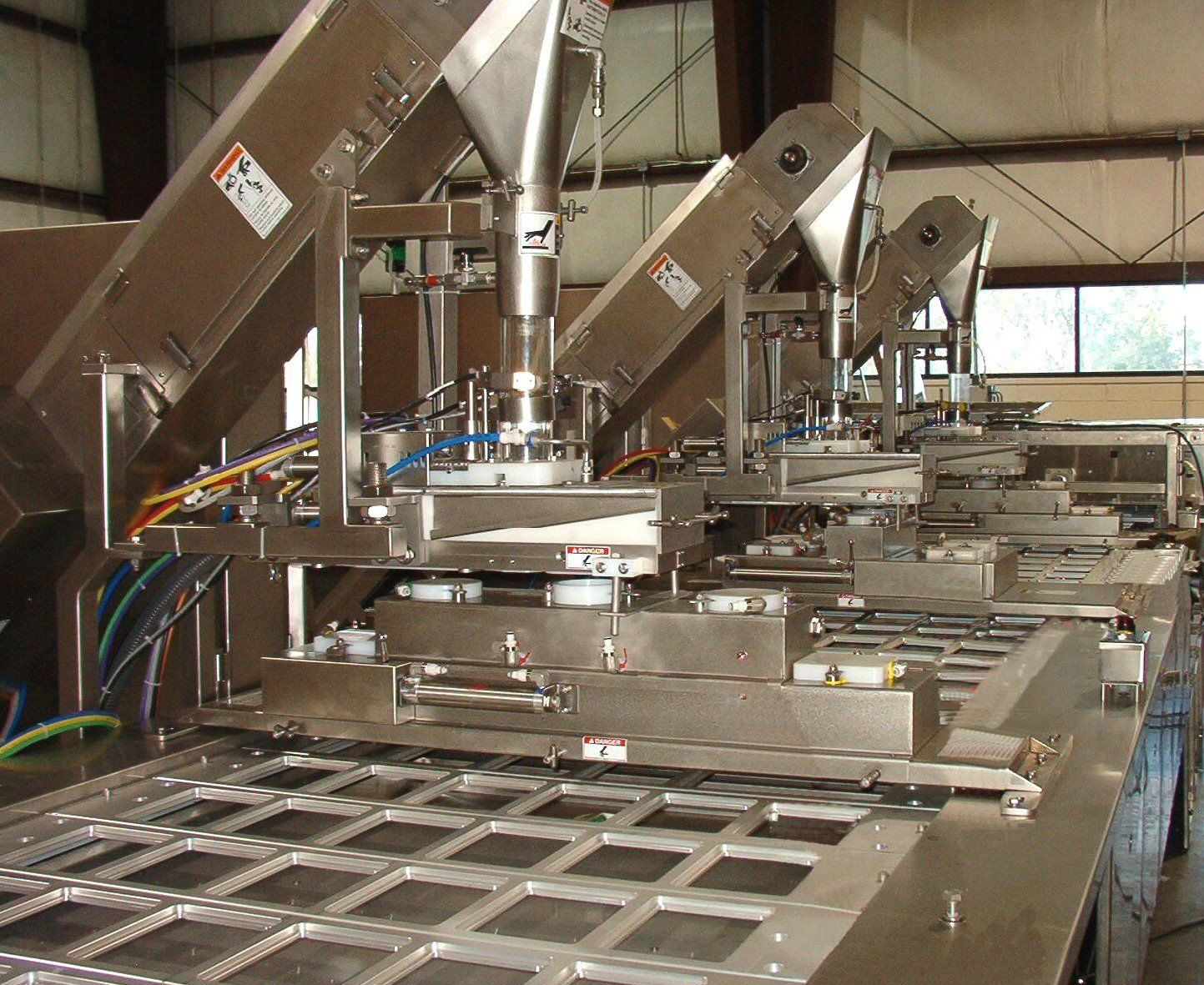 A row of stainless steel machines are lined up in a room