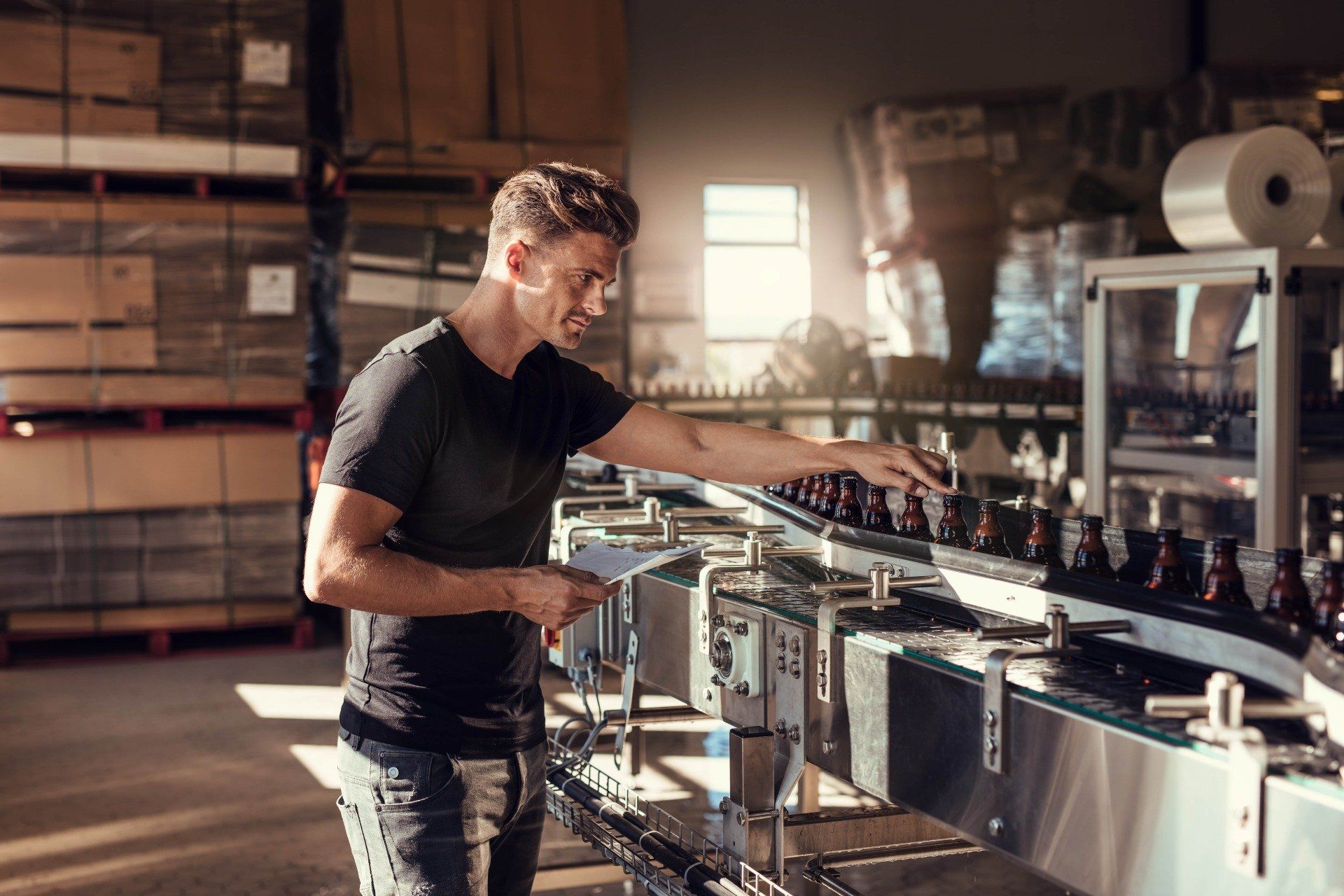 A man is working on a conveyor belt in a factory.