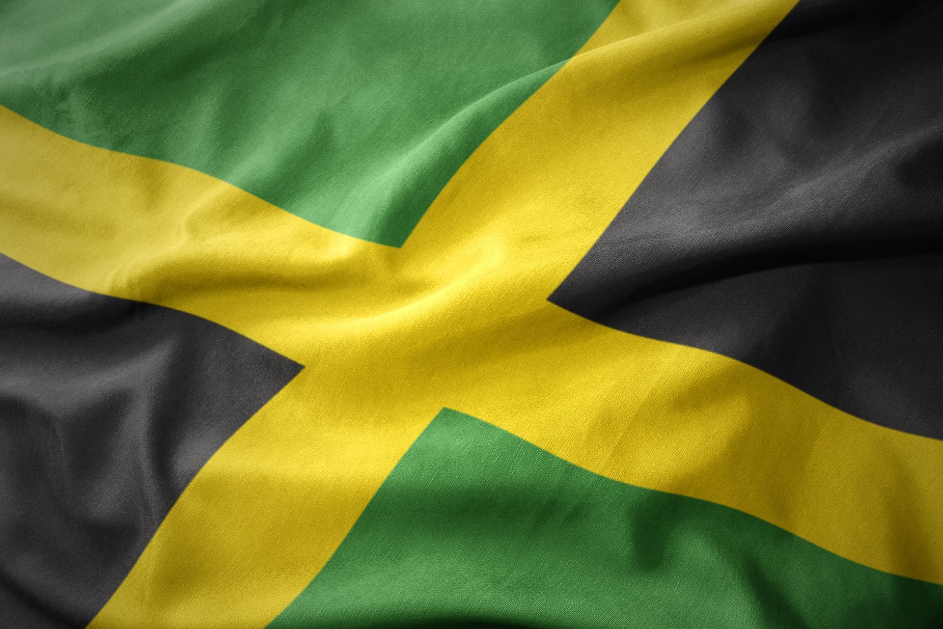 A close up of a jamaican flag waving in the wind