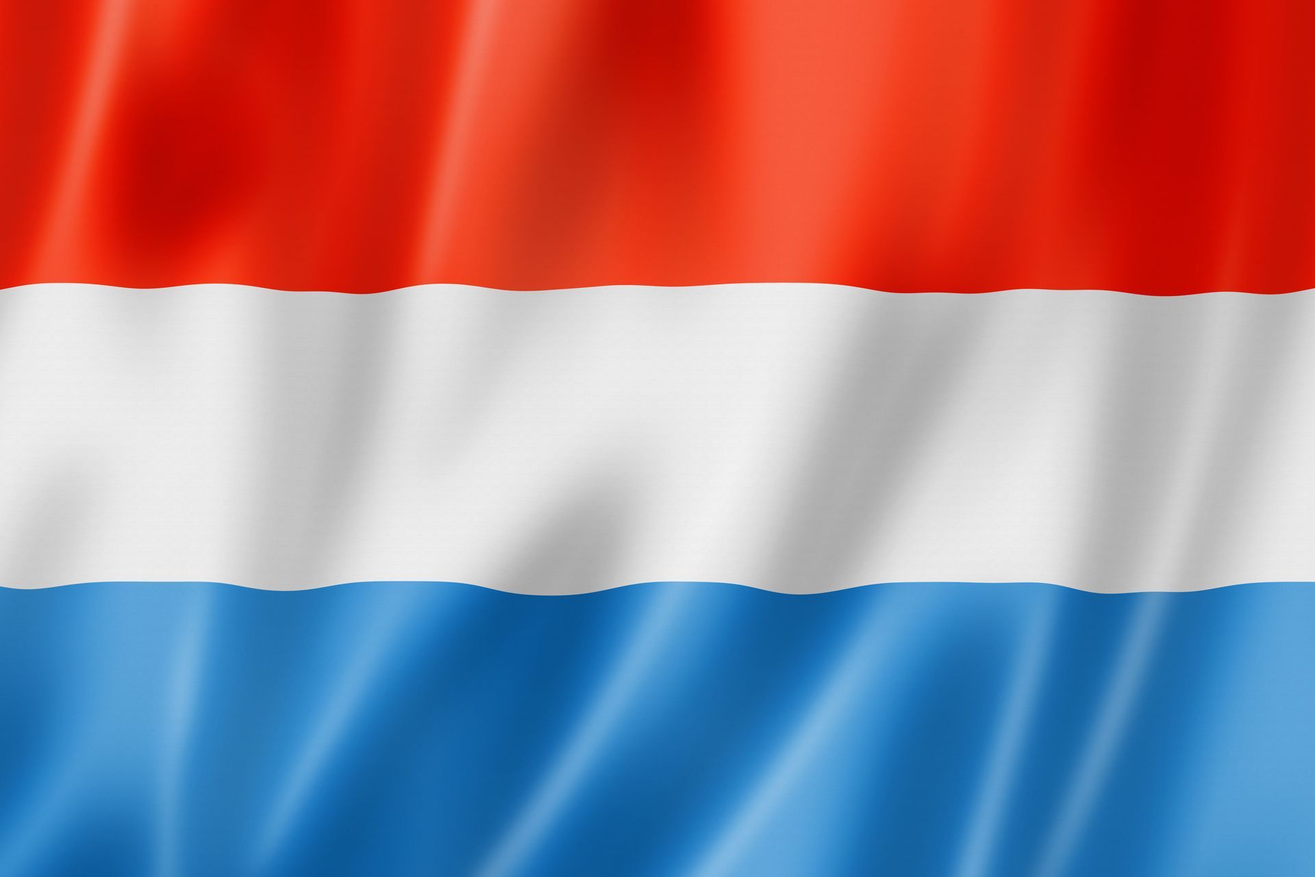 The flag of luxembourg is red , white and blue and is waving in the wind.