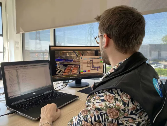 A man is sitting at a desk using a laptop computer.