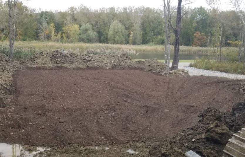 A large pile of dirt is sitting in the middle of a field.
