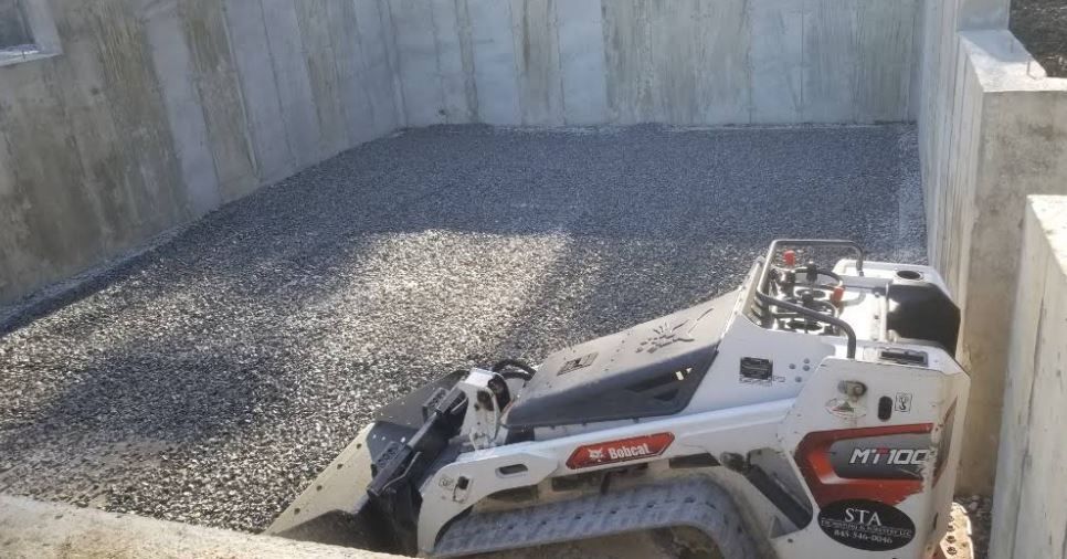 A bulldozer is sitting on top of a pile of gravel.