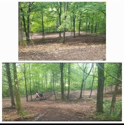 A kubota skid steer is sitting in the middle of a field.
