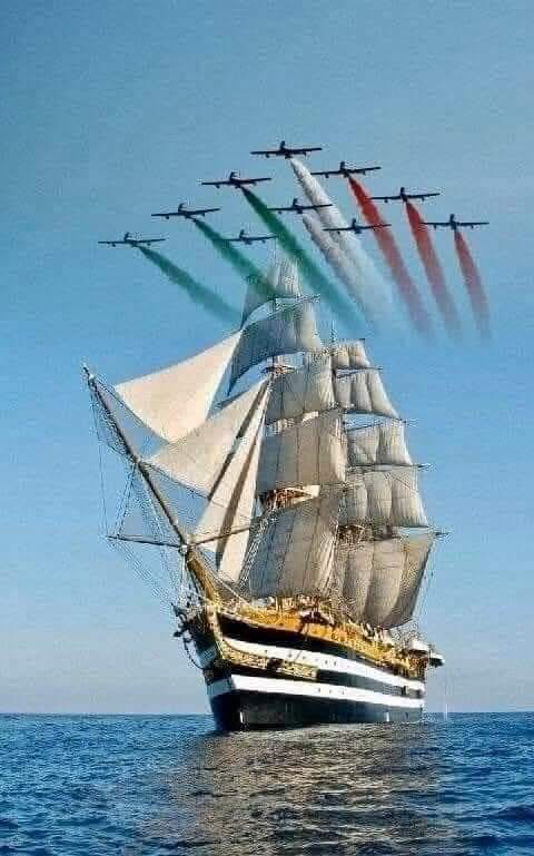 A sailboat in the ocean with planes flying in the background