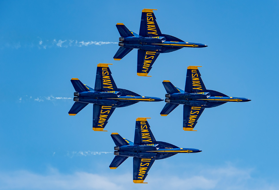 Four us navy fighter jets are flying in formation