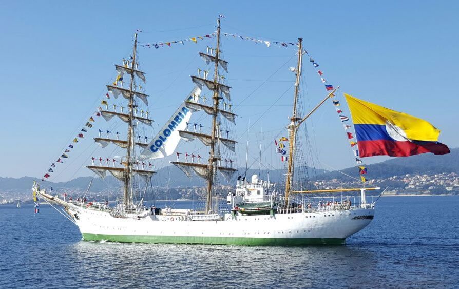 A large sailboat is floating on top of a body of water.