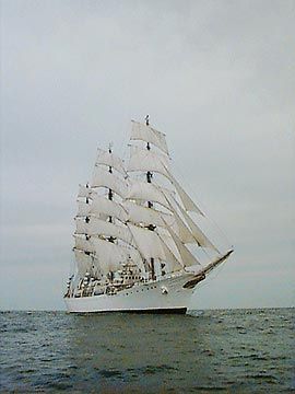 A large sailboat is floating on top of a body of water.