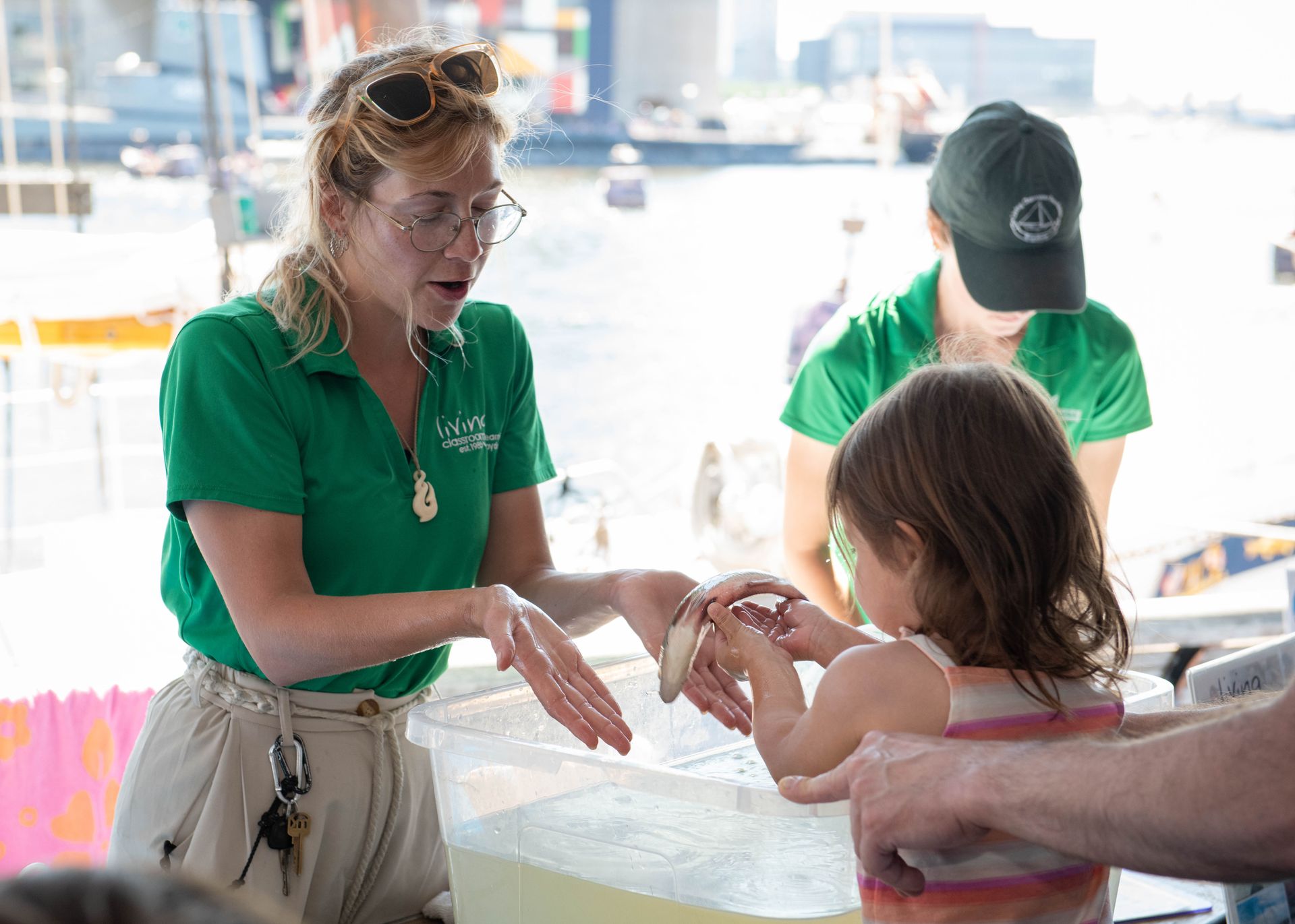 A woman in a green shirt is talking to a little girl.