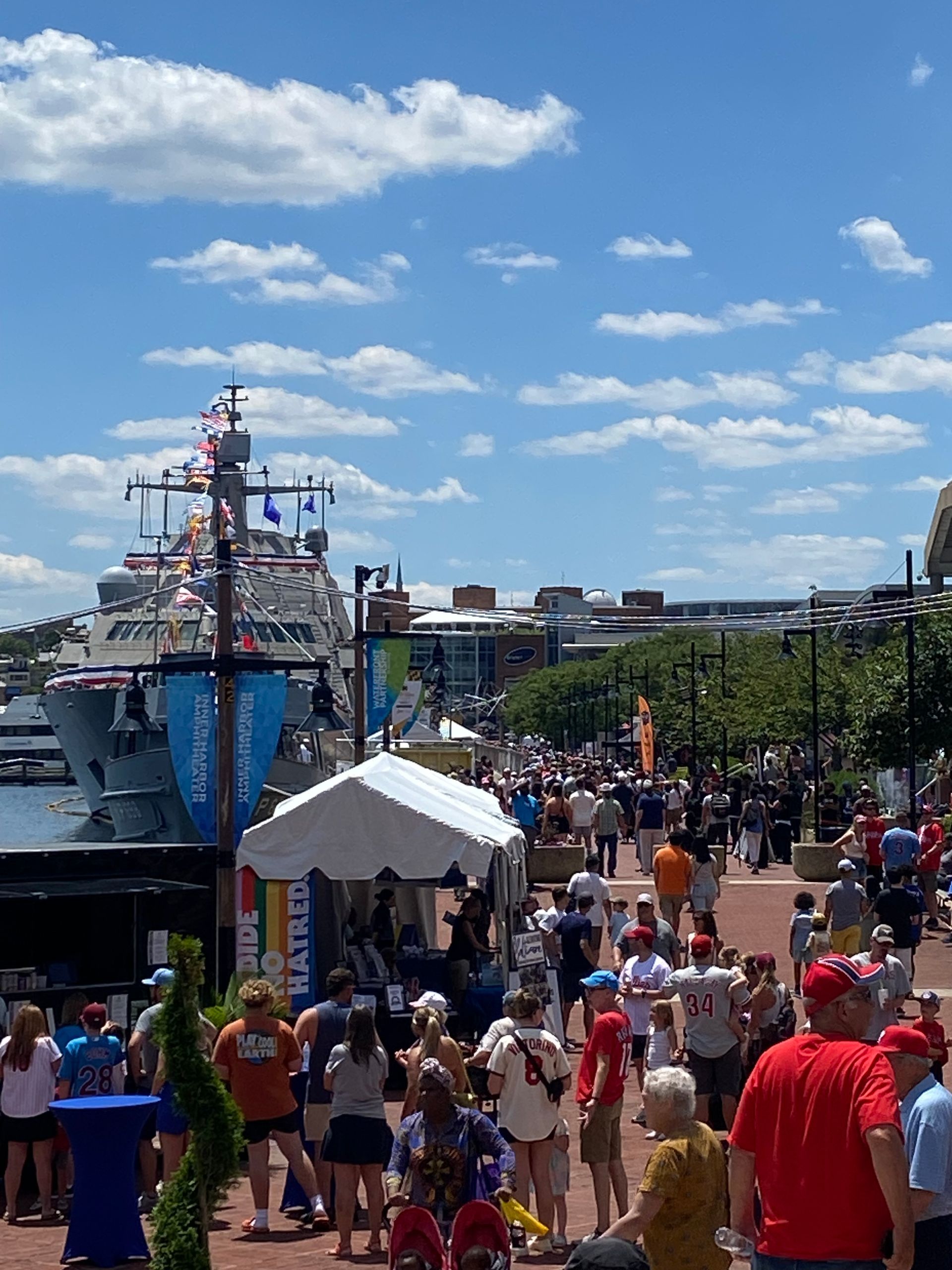 A crowd of people are gathered in front of a large ship