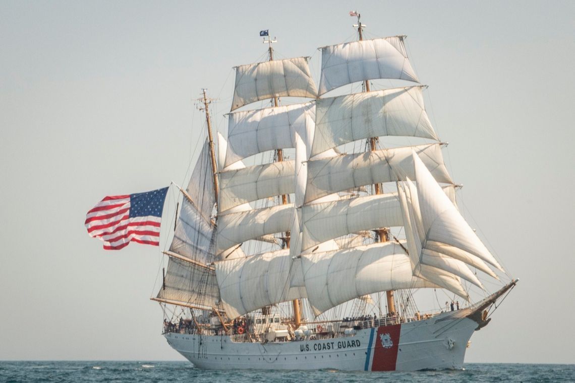 A large sailboat is floating on top of a body of water.