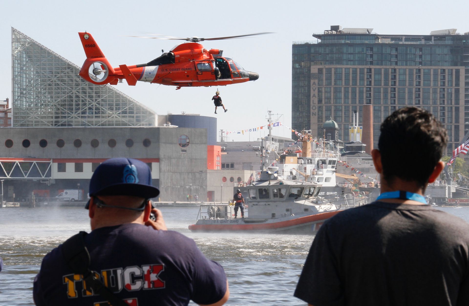 A man wearing a shirt that says truck is taking a picture of a helicopter
