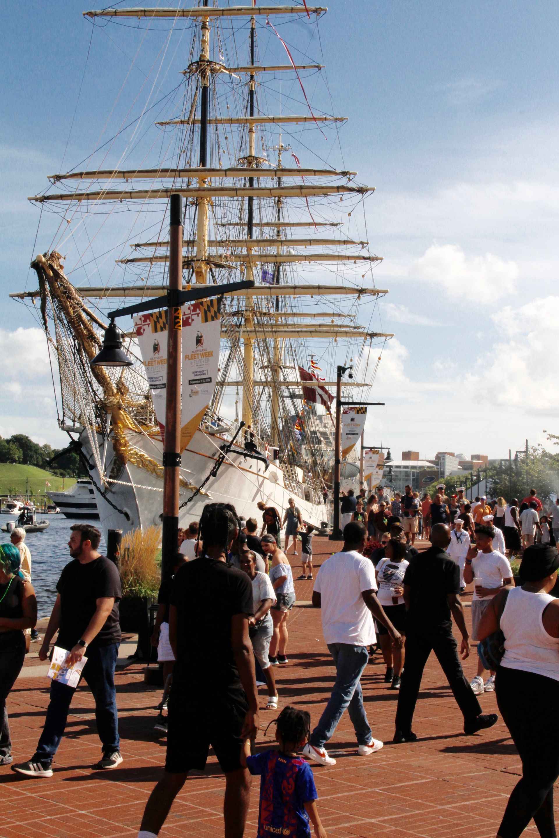 Three people are posing for a picture in front of a navy.com tent.