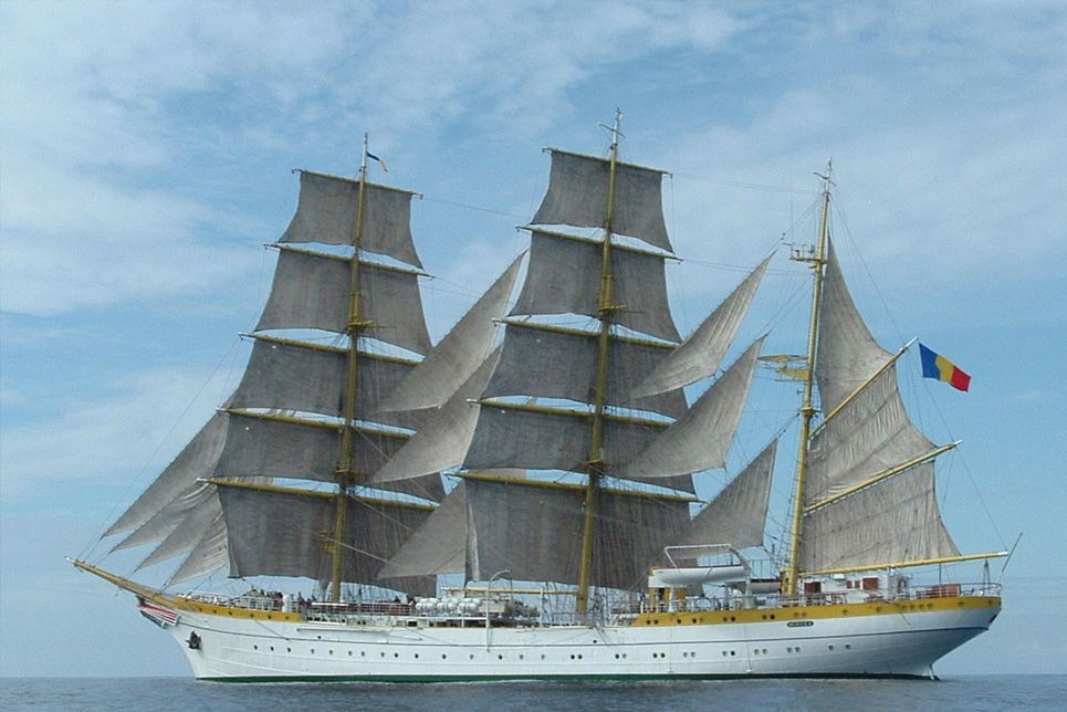 A large sailboat with a romanian flag on the side