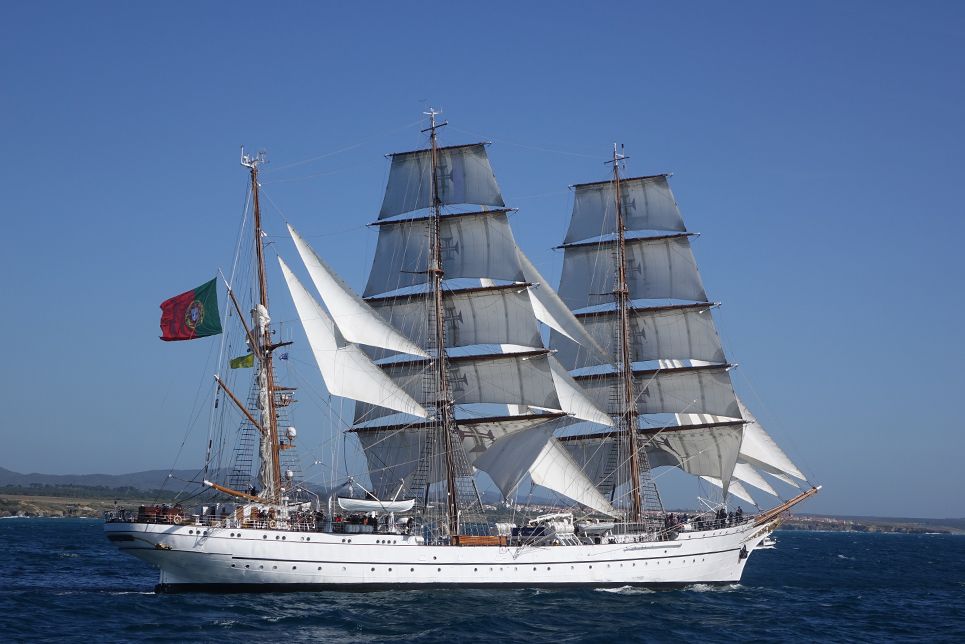 A large sailboat is floating on top of a body of water.