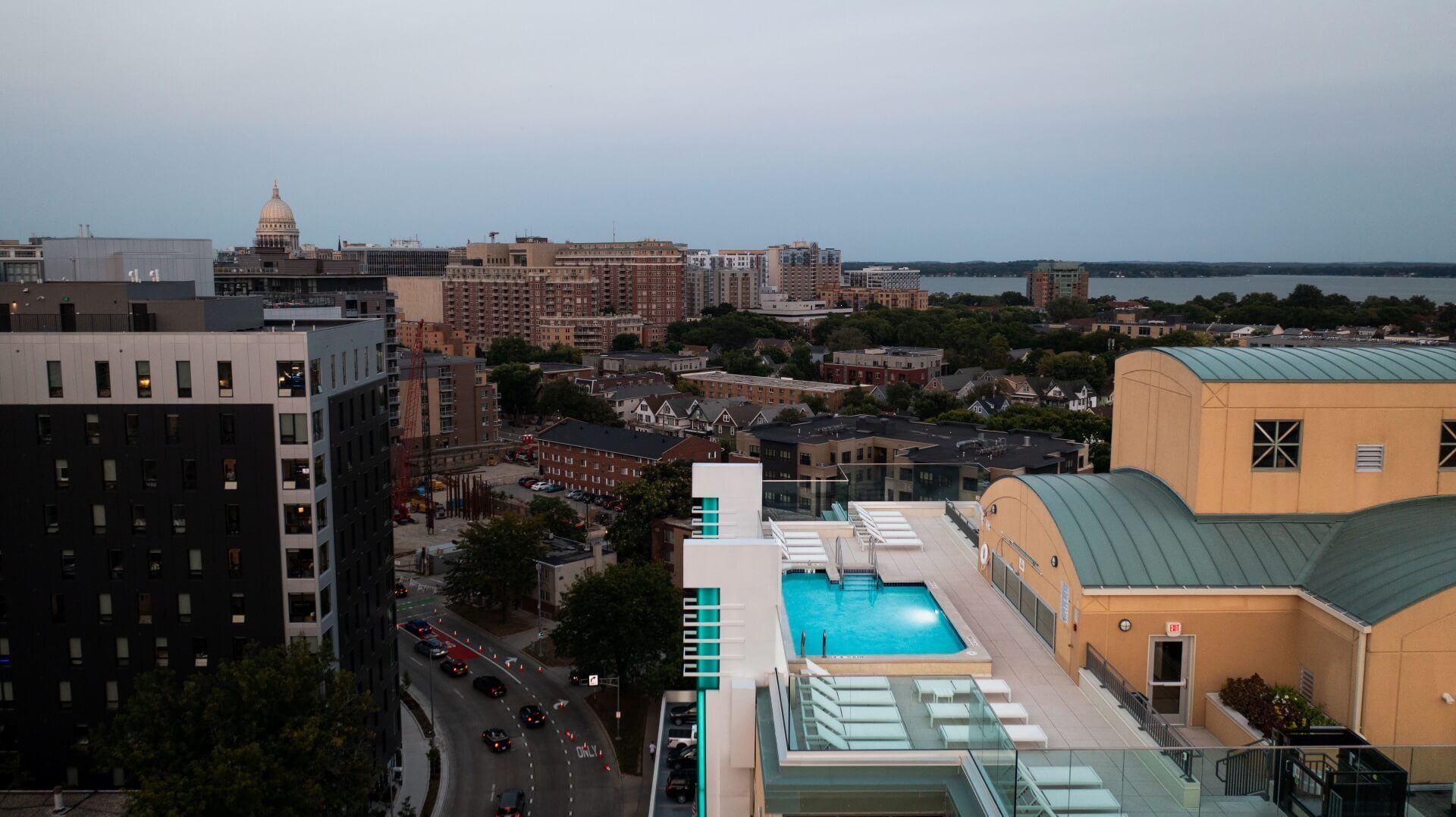 An aerial view of a city with a swimming pool on the roof of a building.