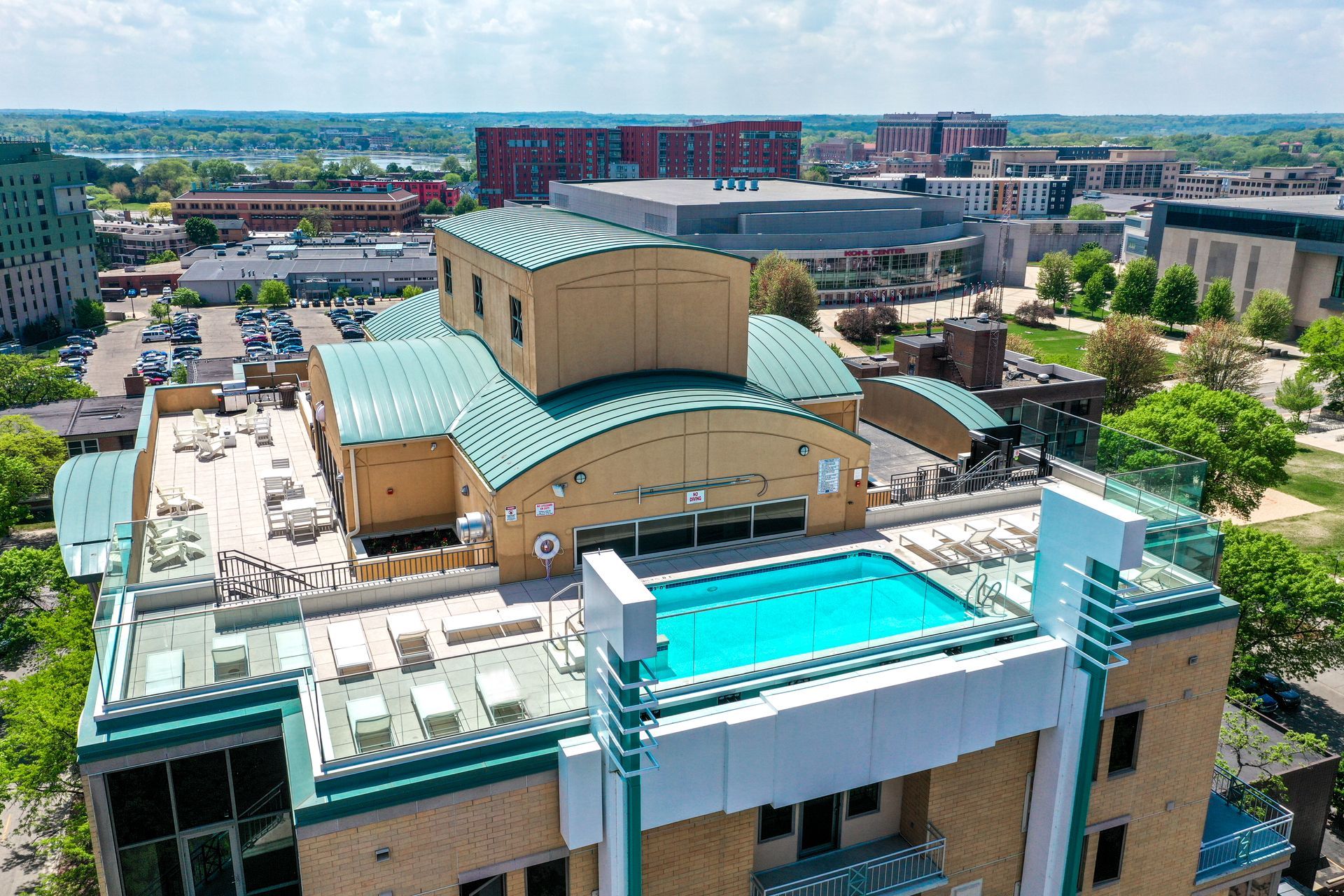 An aerial view of a building with a pool on the roof