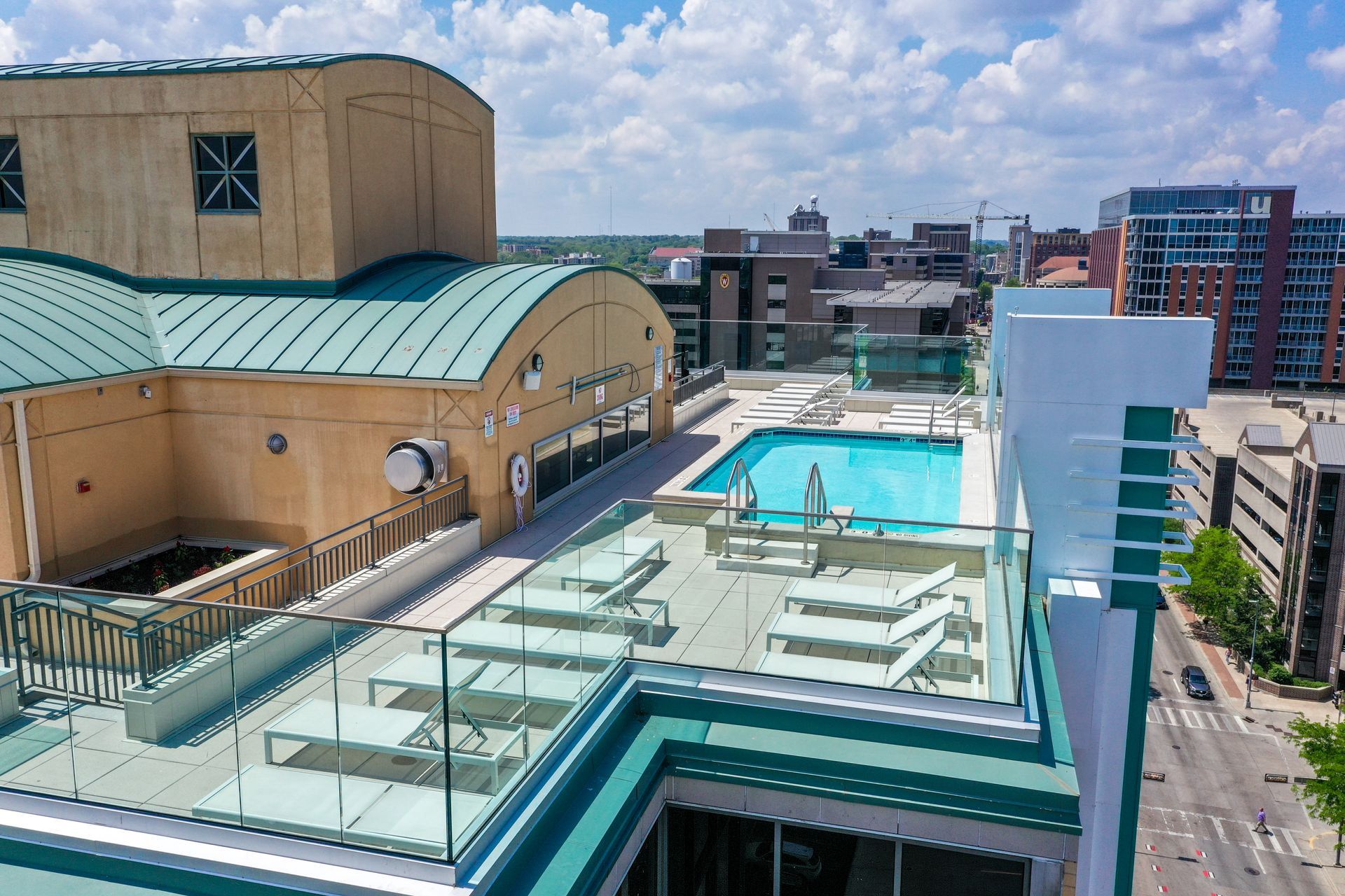 An aerial view of a large swimming pool on the roof of a building.