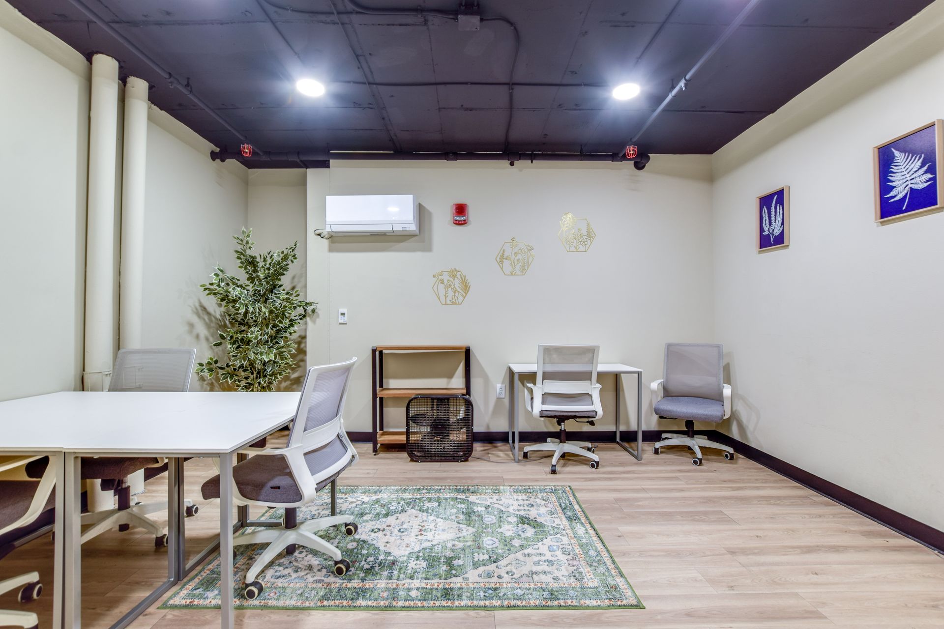 There are three desks and chairs in the room.