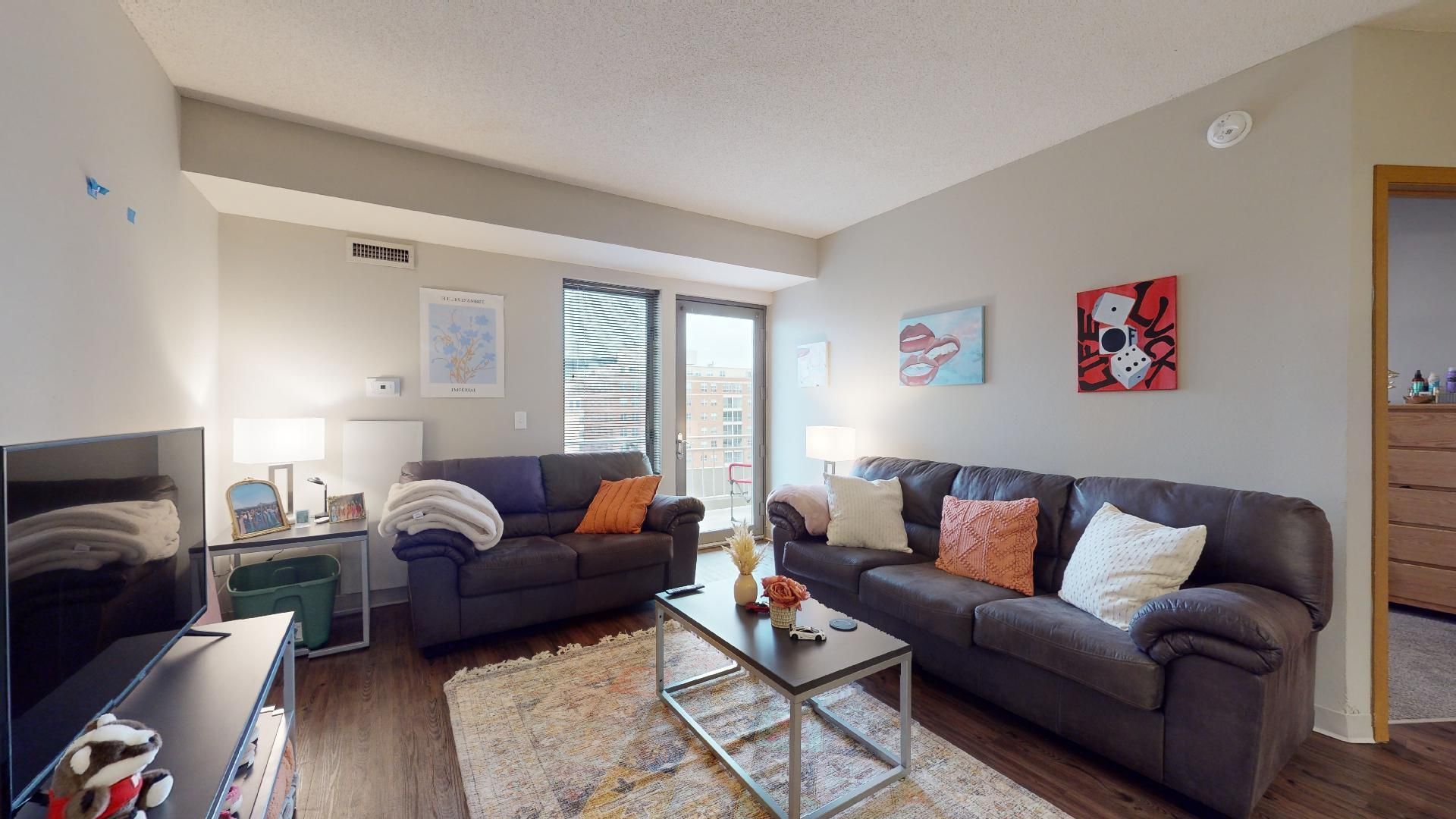 A living room with two couches , a coffee table , and a television.