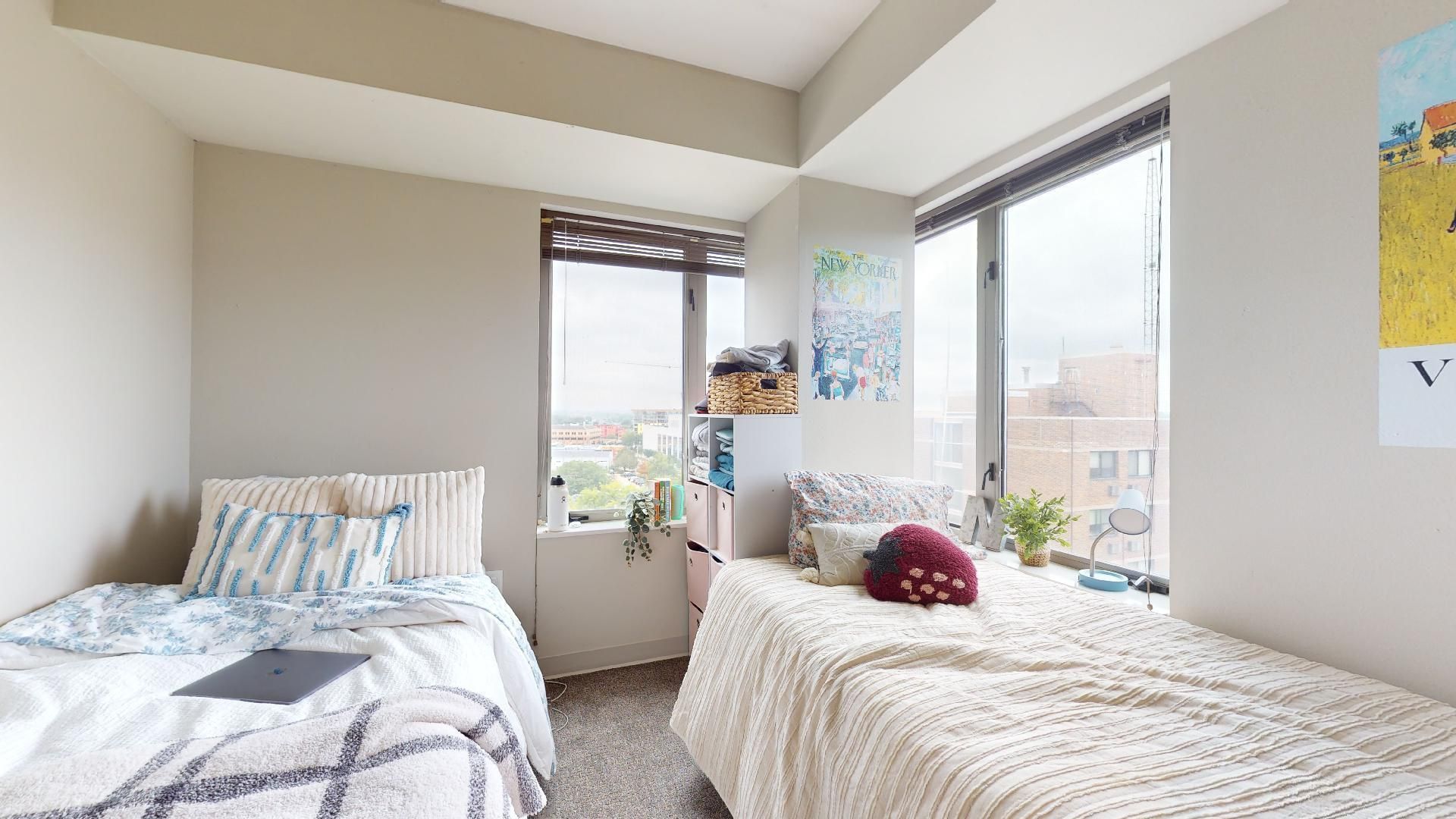 A bedroom with two beds and a large window.