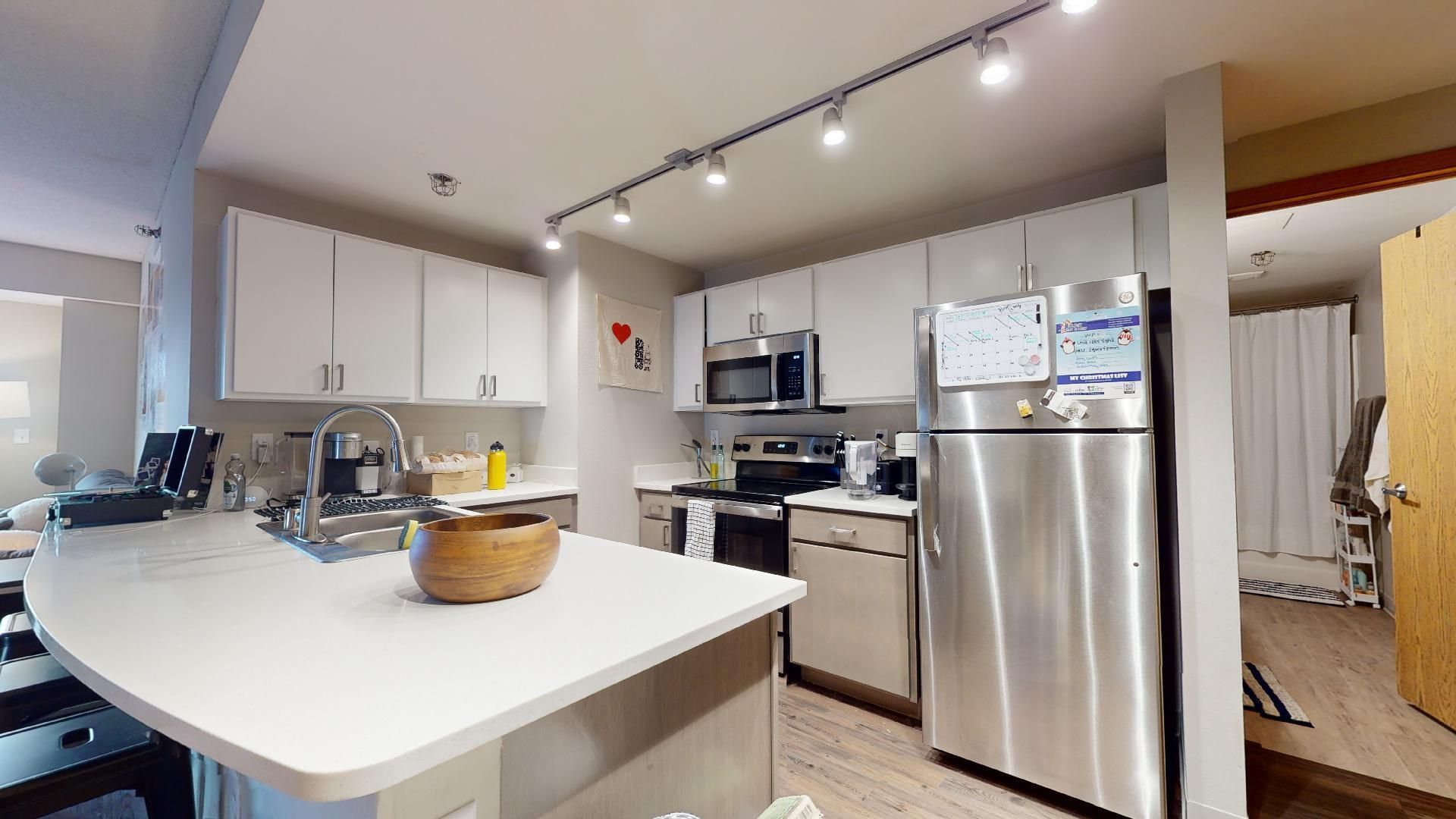 A kitchen with stainless steel appliances and white cabinets