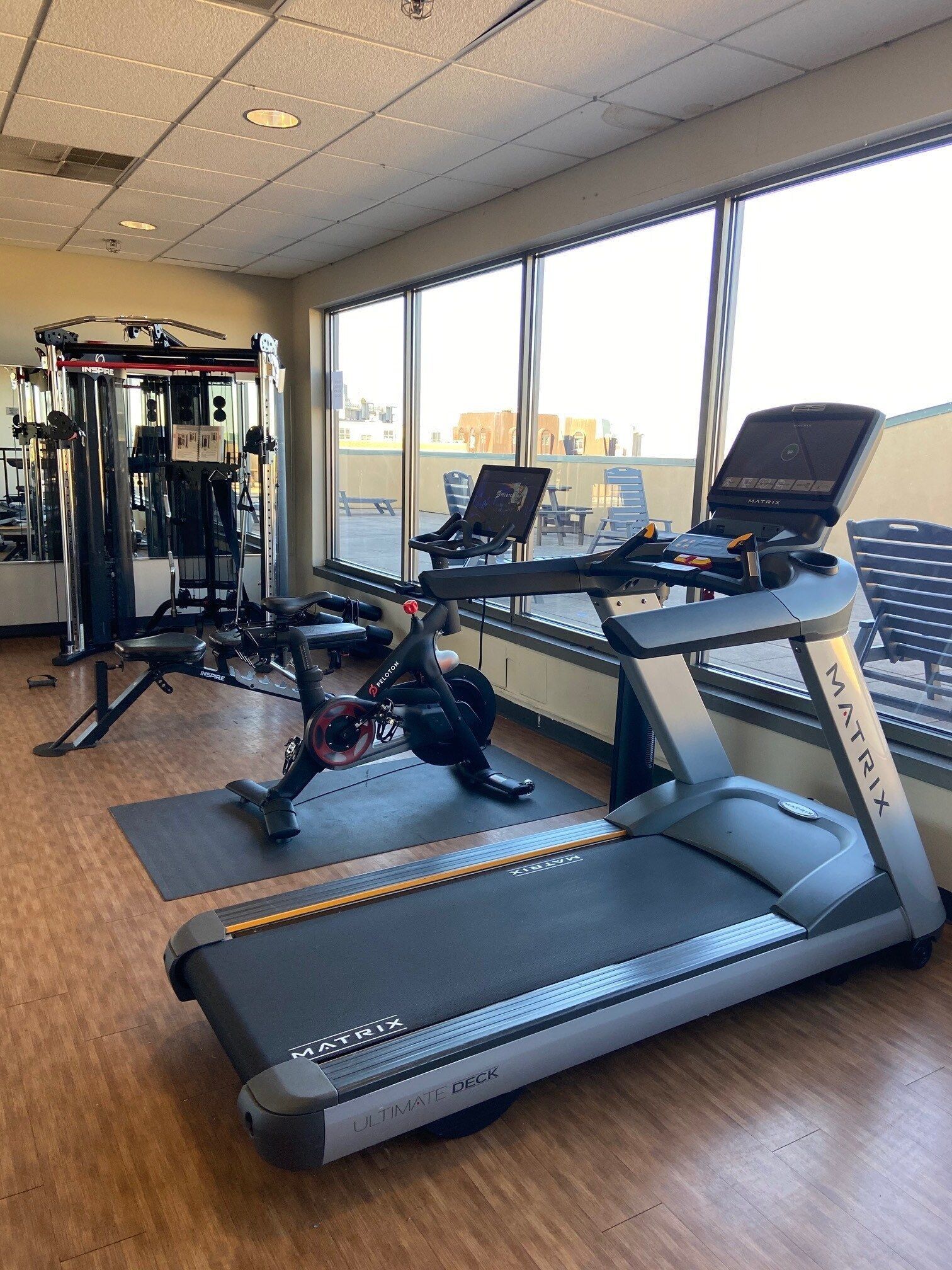 A treadmill is sitting in a gym next to a window.