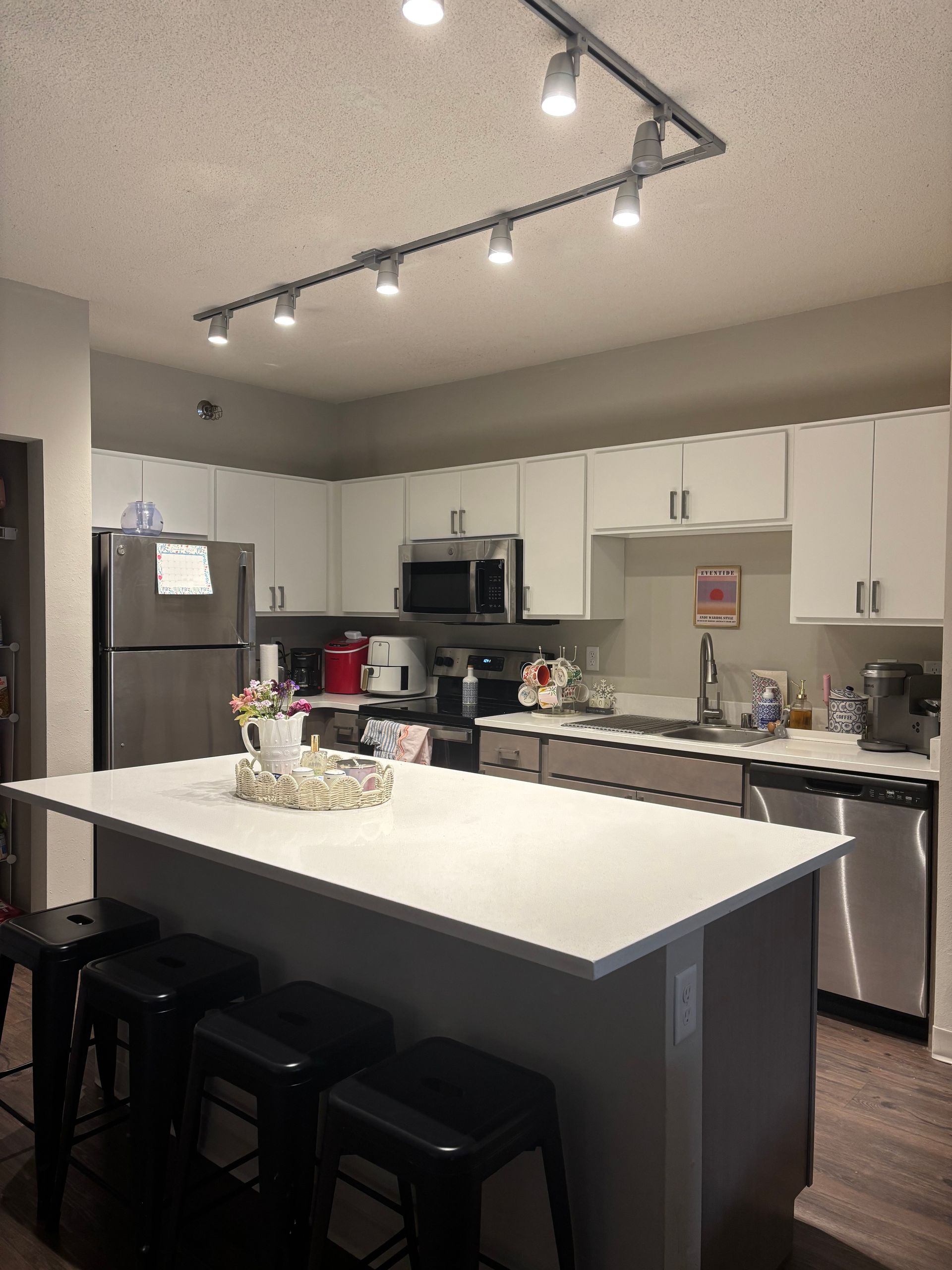 A kitchen with white cabinets and stainless steel appliances