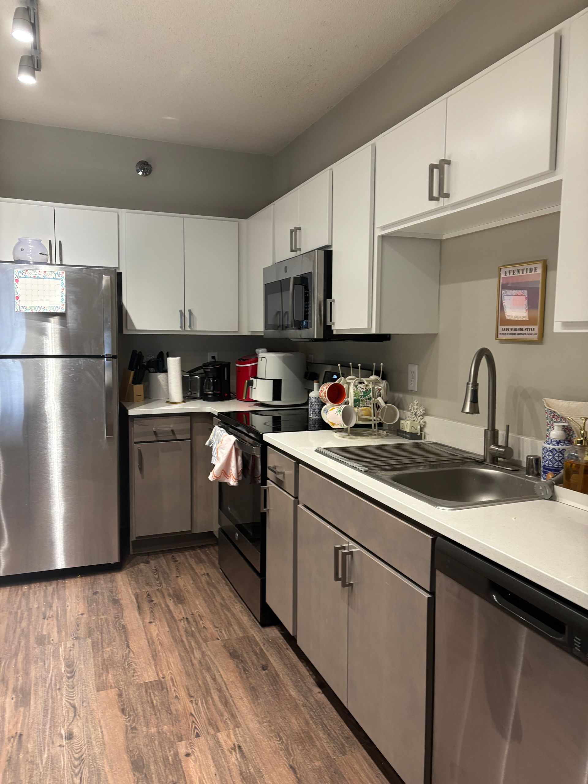 A kitchen with stainless steel appliances and white cabinets