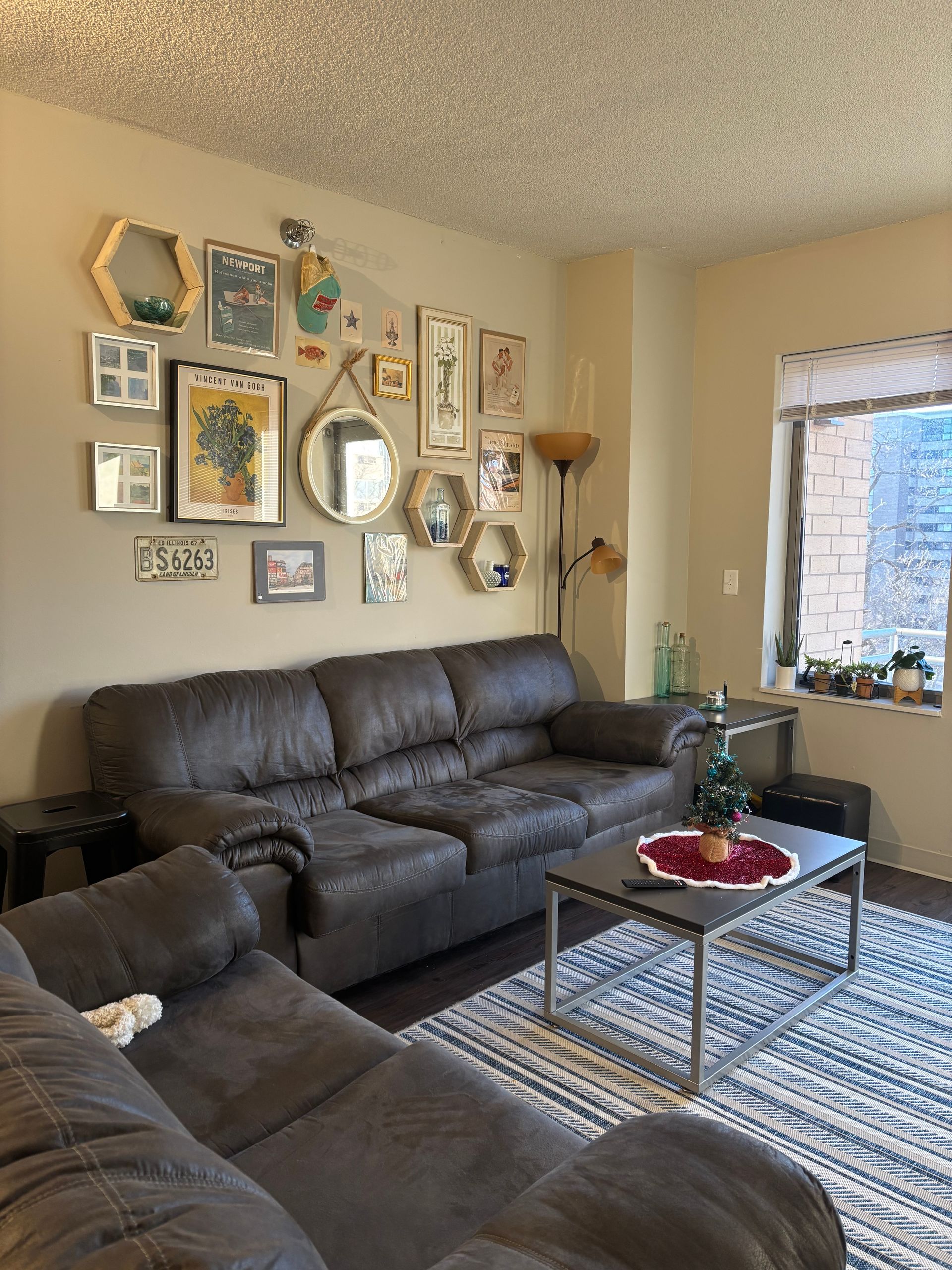 A living room with a couch , coffee table , and pictures on the wall.