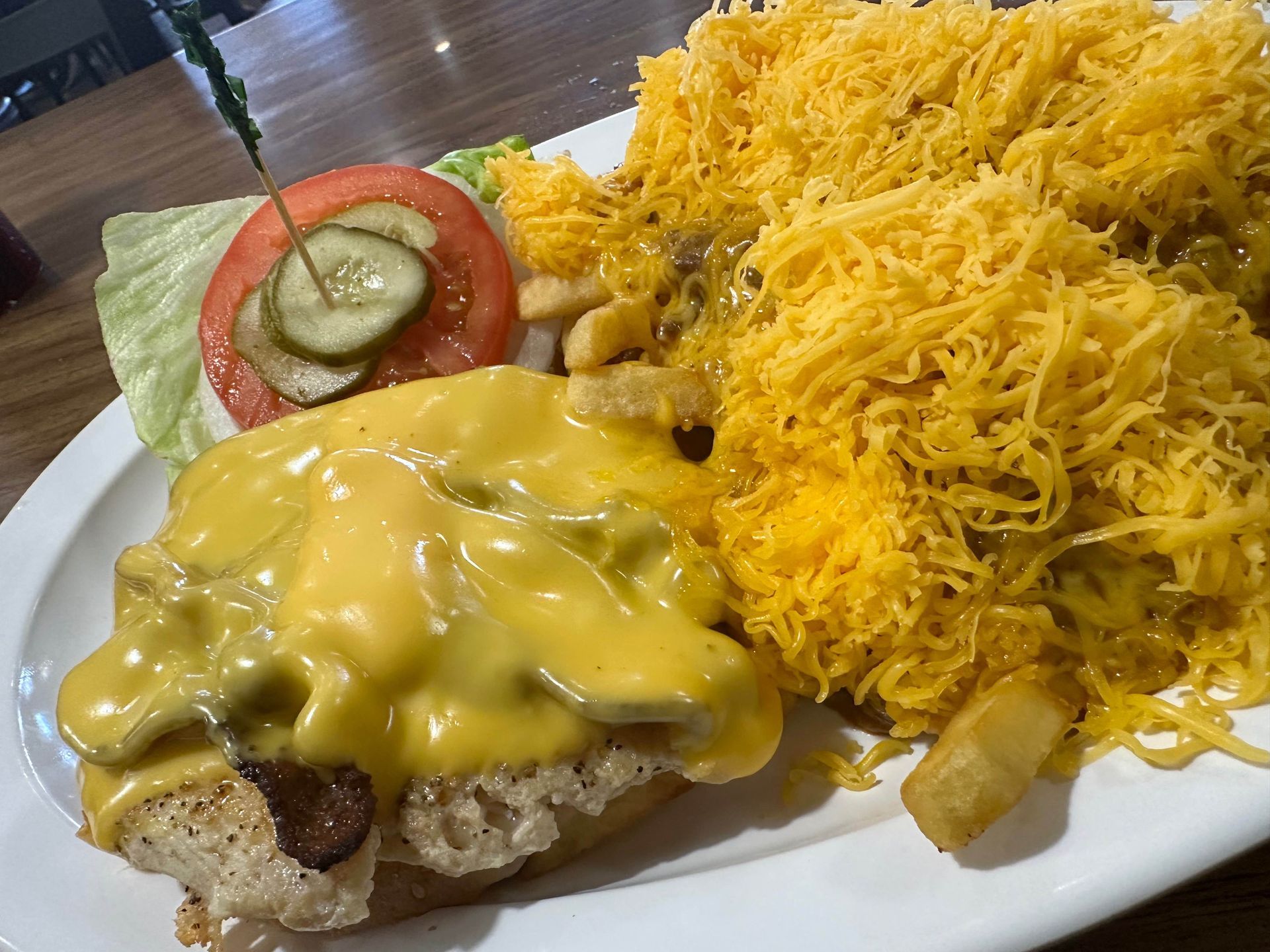 A close up of a plate of food with a sandwich and cheese on a table.