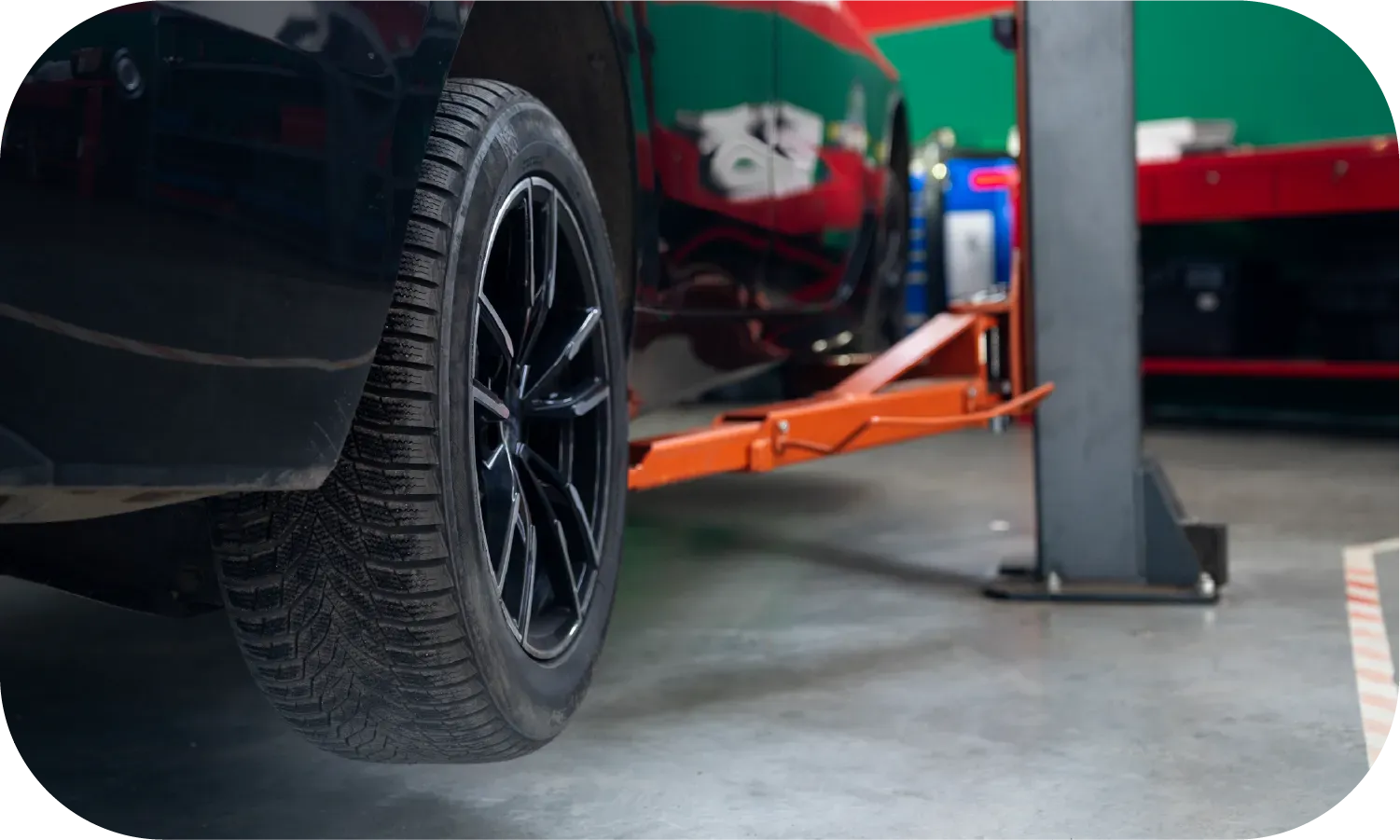 A car is sitting on a lift in a garage.