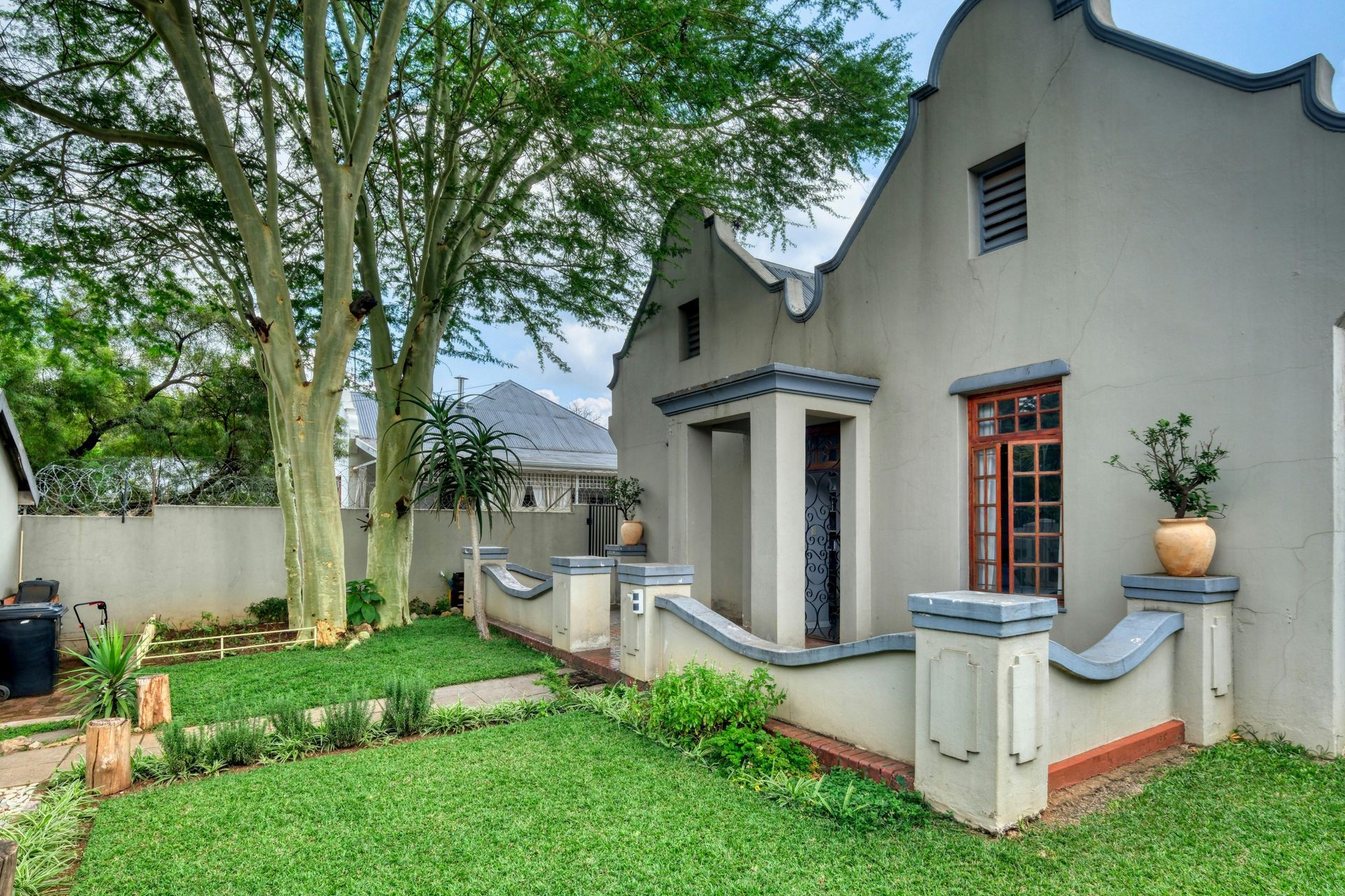 A white house with a lush green lawn in front of it.