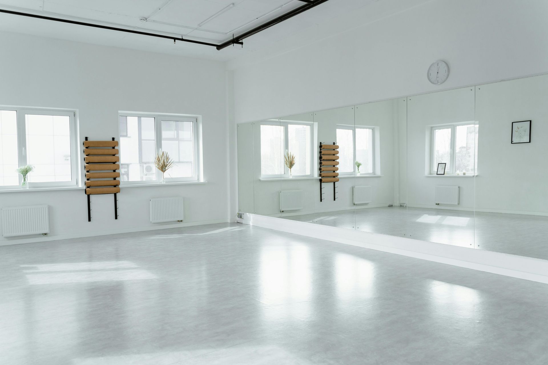 An empty dance studio with a large mirror on the wall.