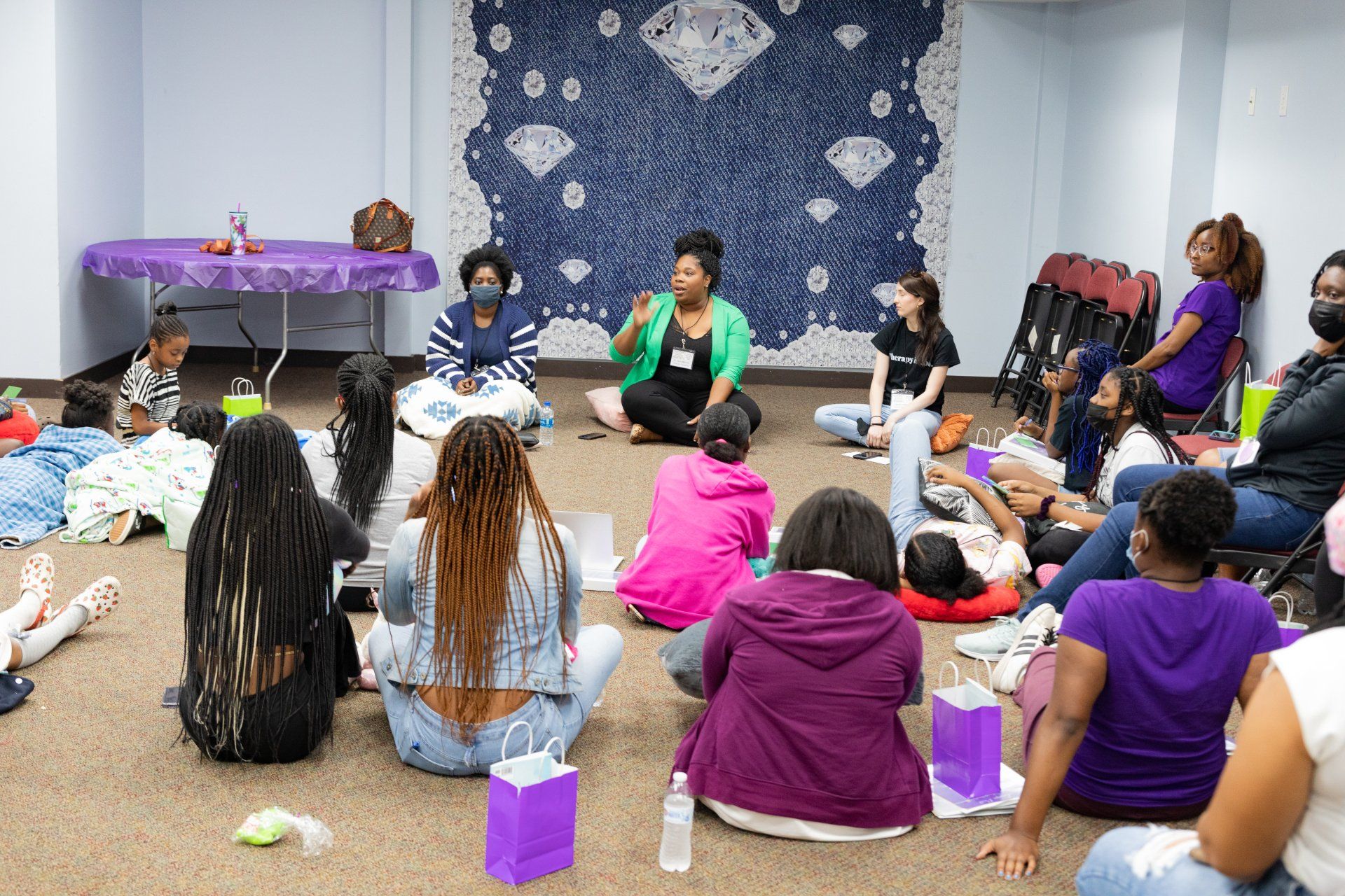 a group of women sit in a circle on the floor