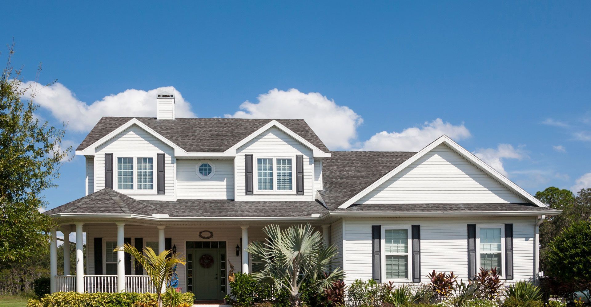 A white house with a gray roof and black shutters