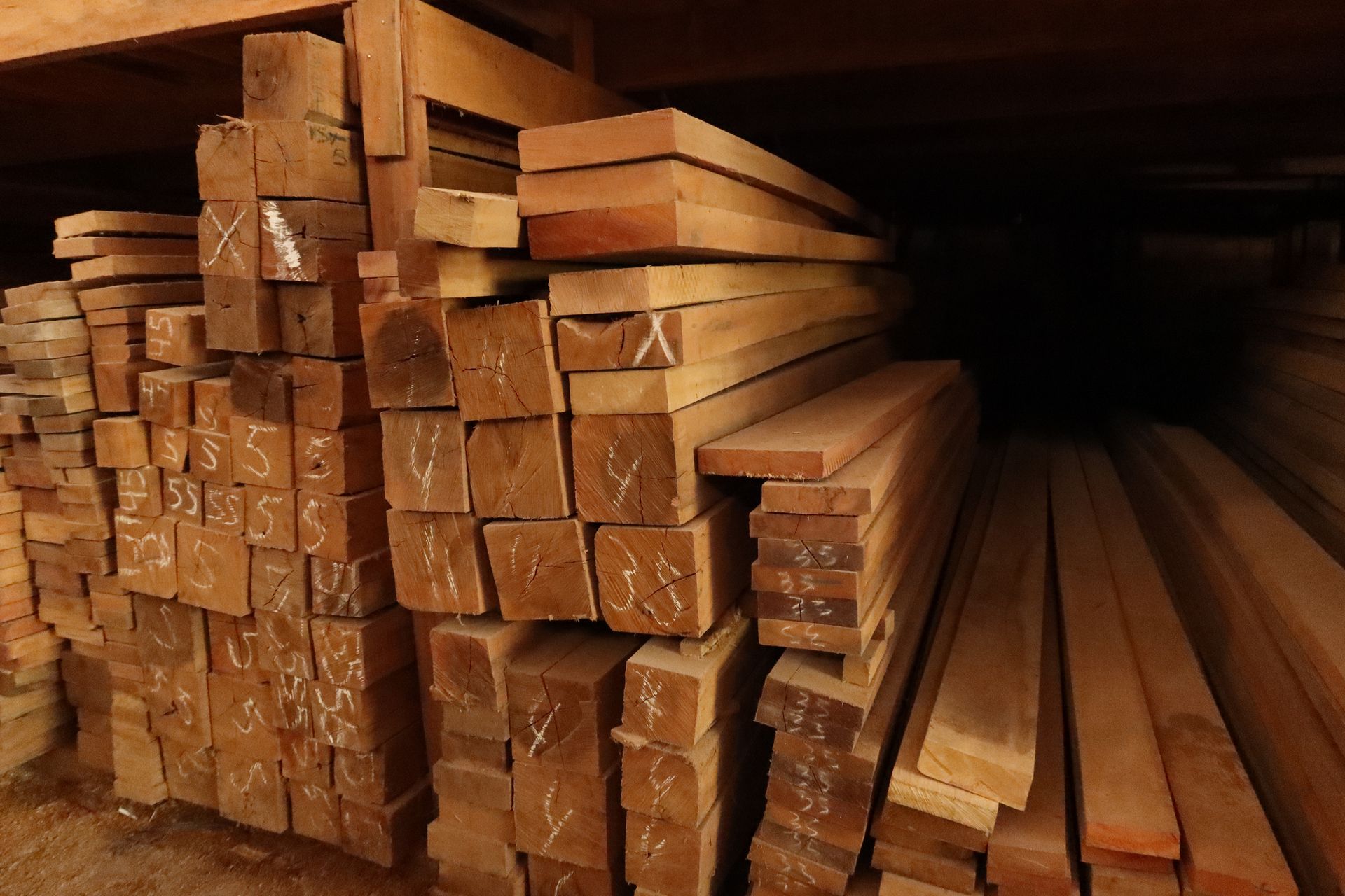 Wood sawn in a lumberyard, slats, boards, pillars stocked in a pile.