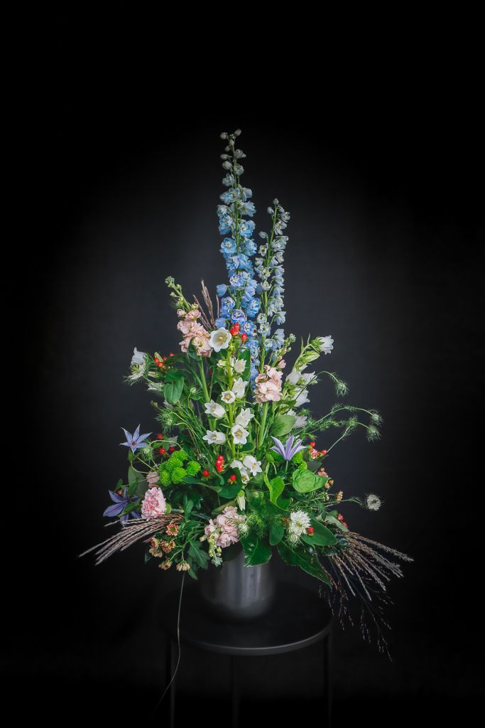 Op een tafel staat een vaas met bloemen.