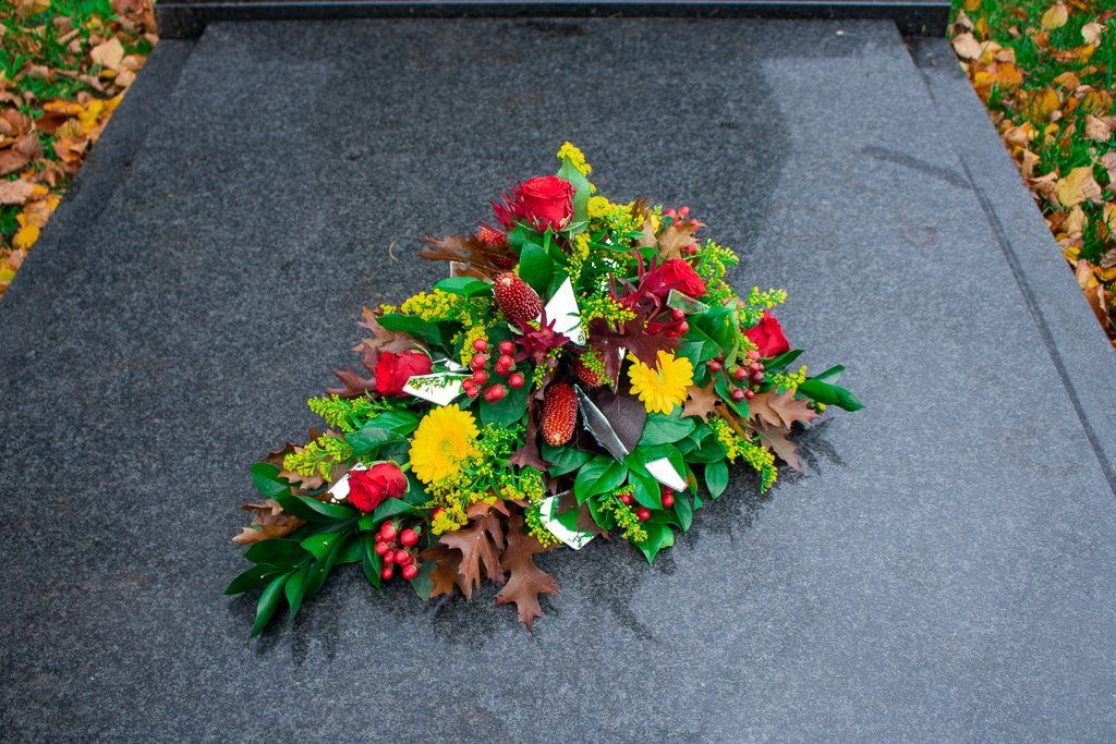 Een graf met rouwbloemen, blog de kracht van bloemen.