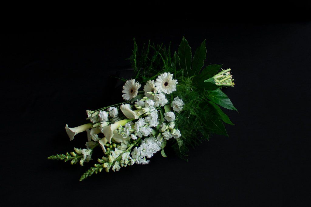 Een boeket witte bloemen op een zwarte achtergrond.