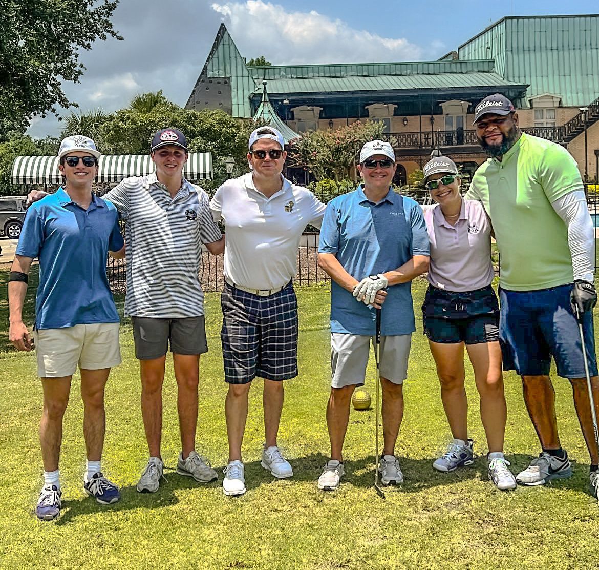 A group of people are posing for a picture on a golf course.
