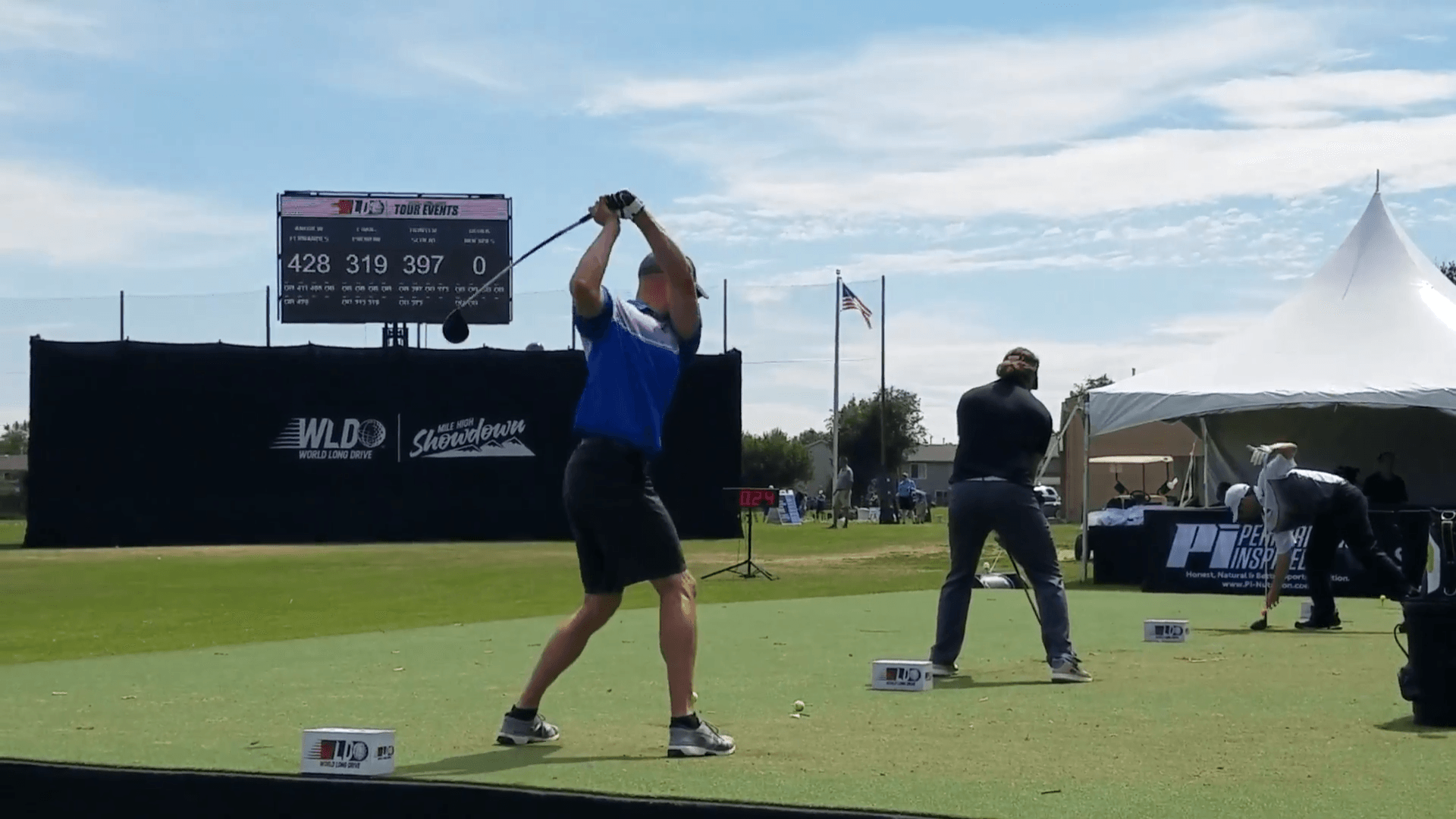 A man is swinging a golf club on a golf course.