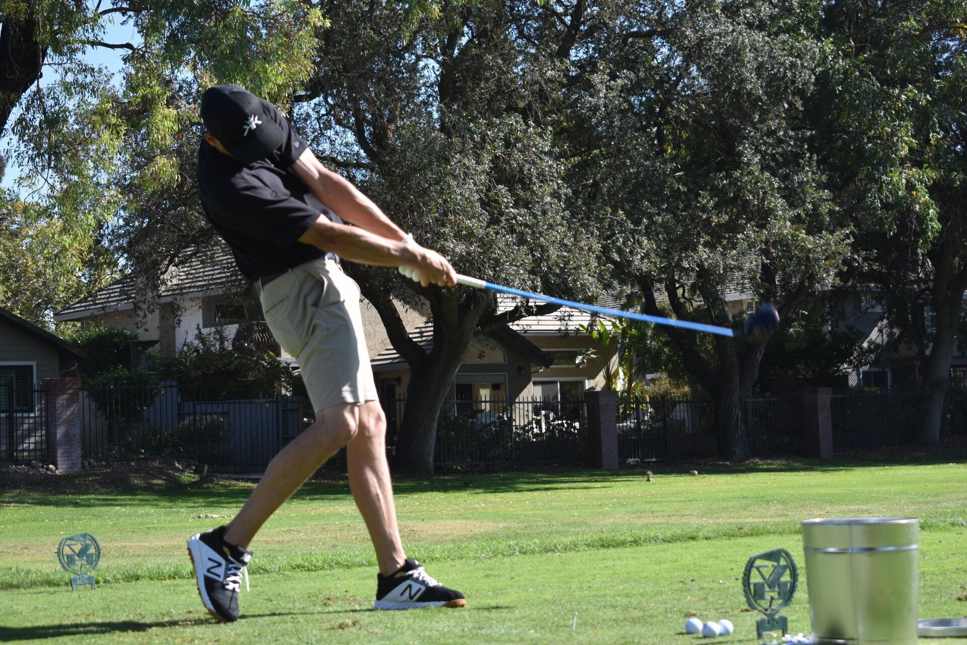 A man is swinging a golf club on a golf course