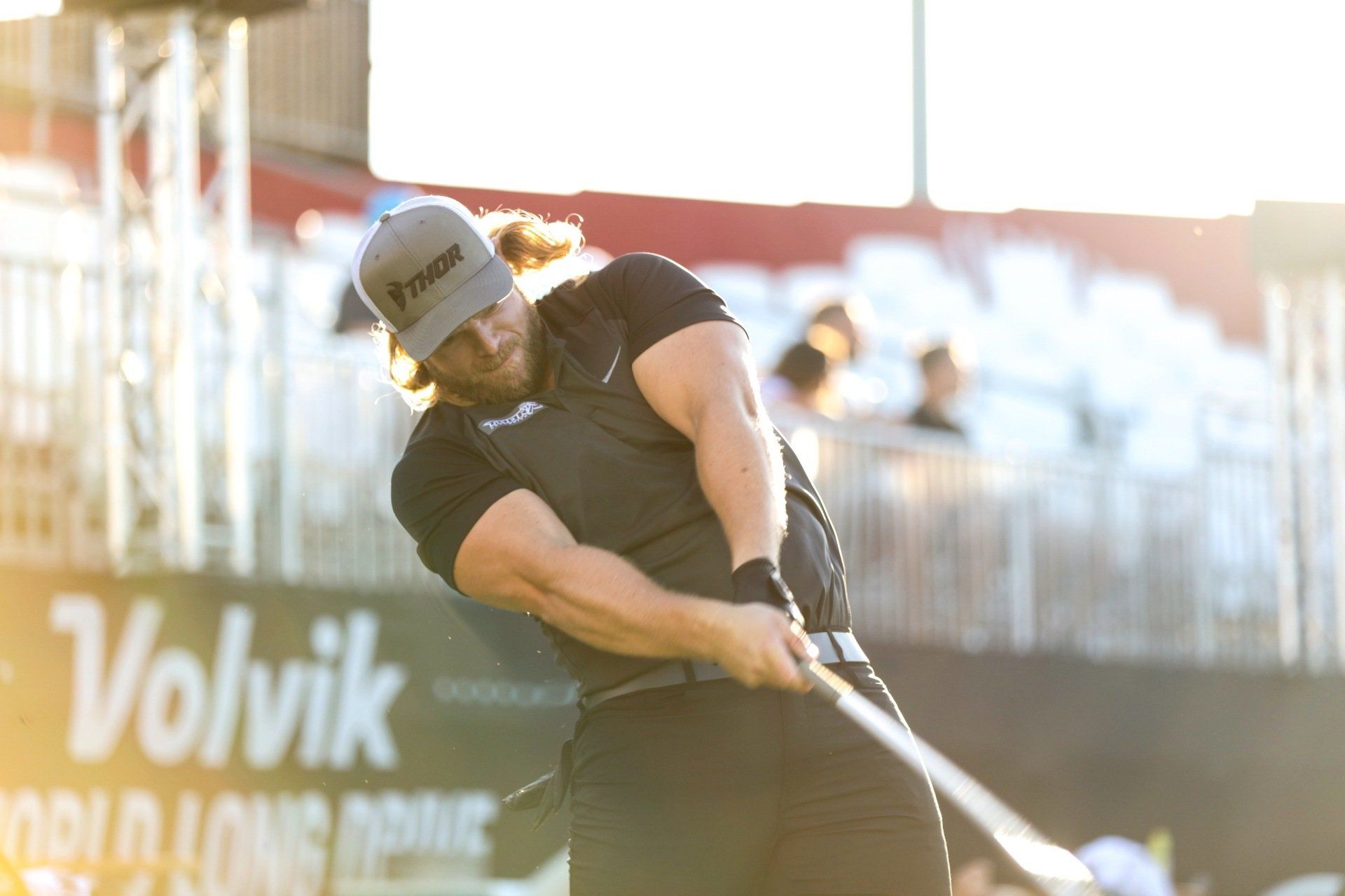 A man is swinging a golf club on a golf course.