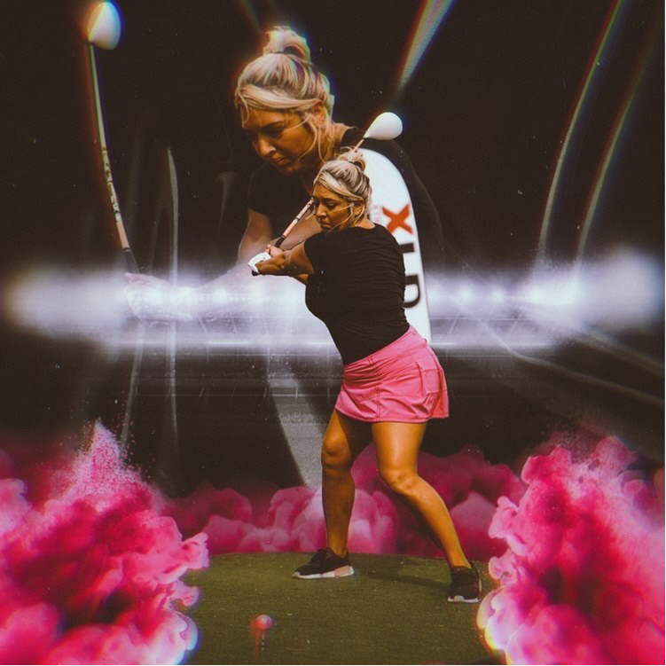 A woman in a pink skirt is swinging a golf club